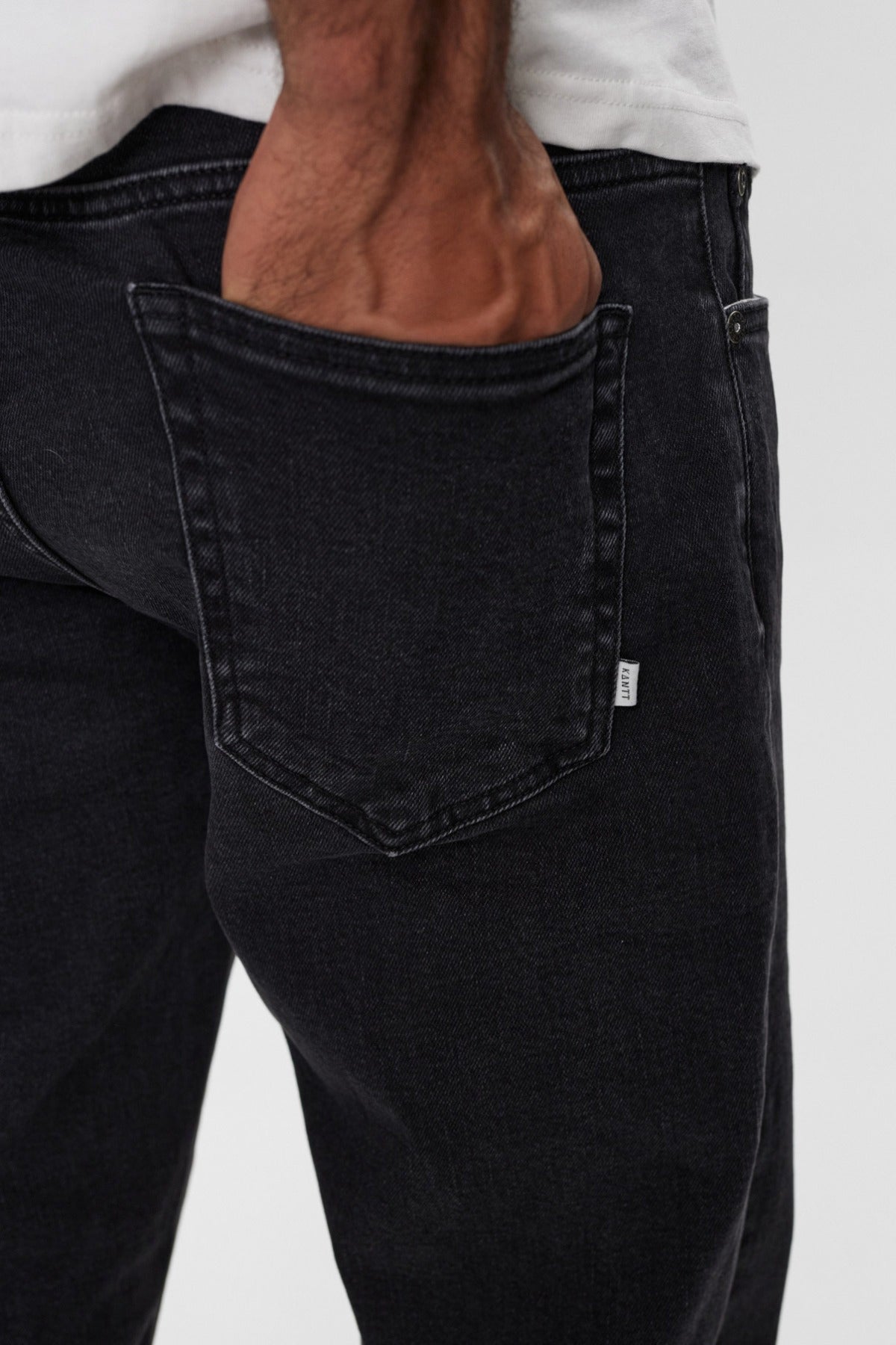 Sorte denimjeans med baglomme og subtile sømme, afslappet pasform nær hoften.