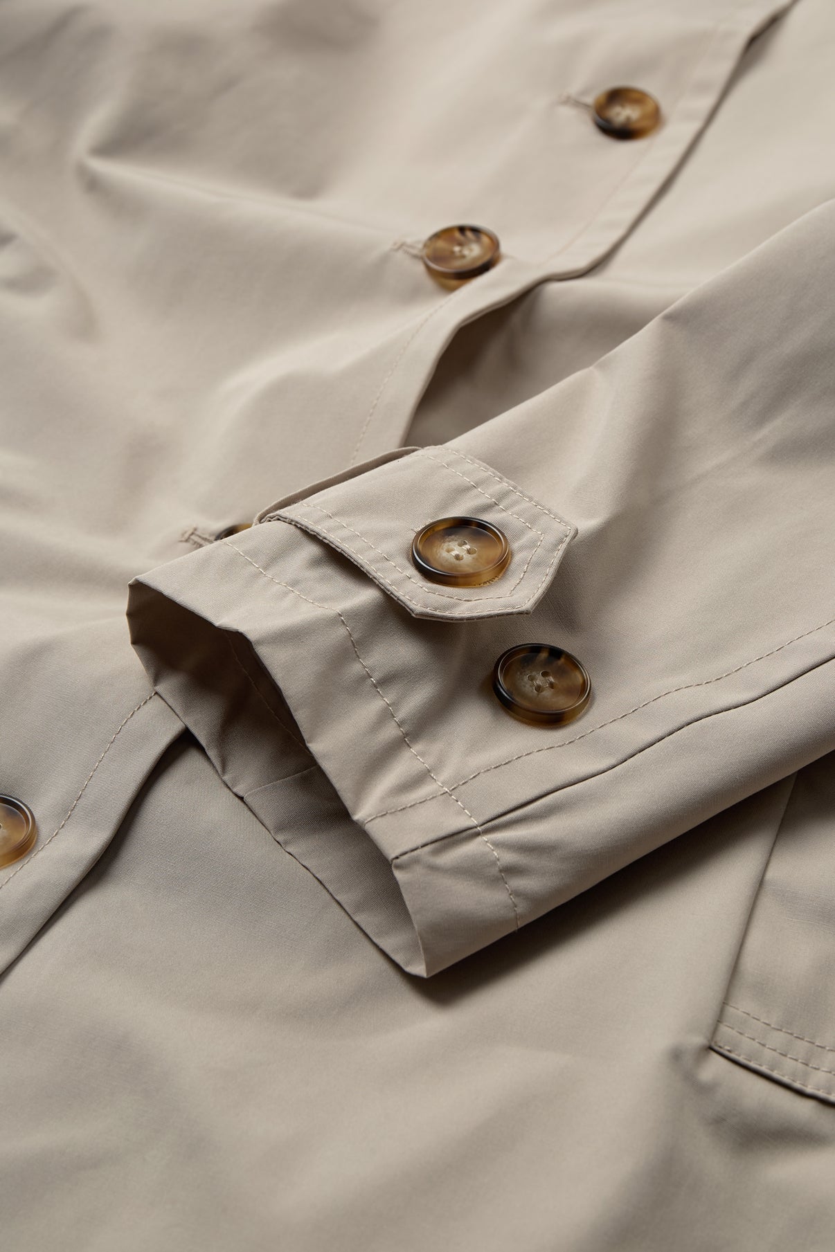 Beige oversize trenchcoat i ren cashmere med knapper i trælook og lommer.