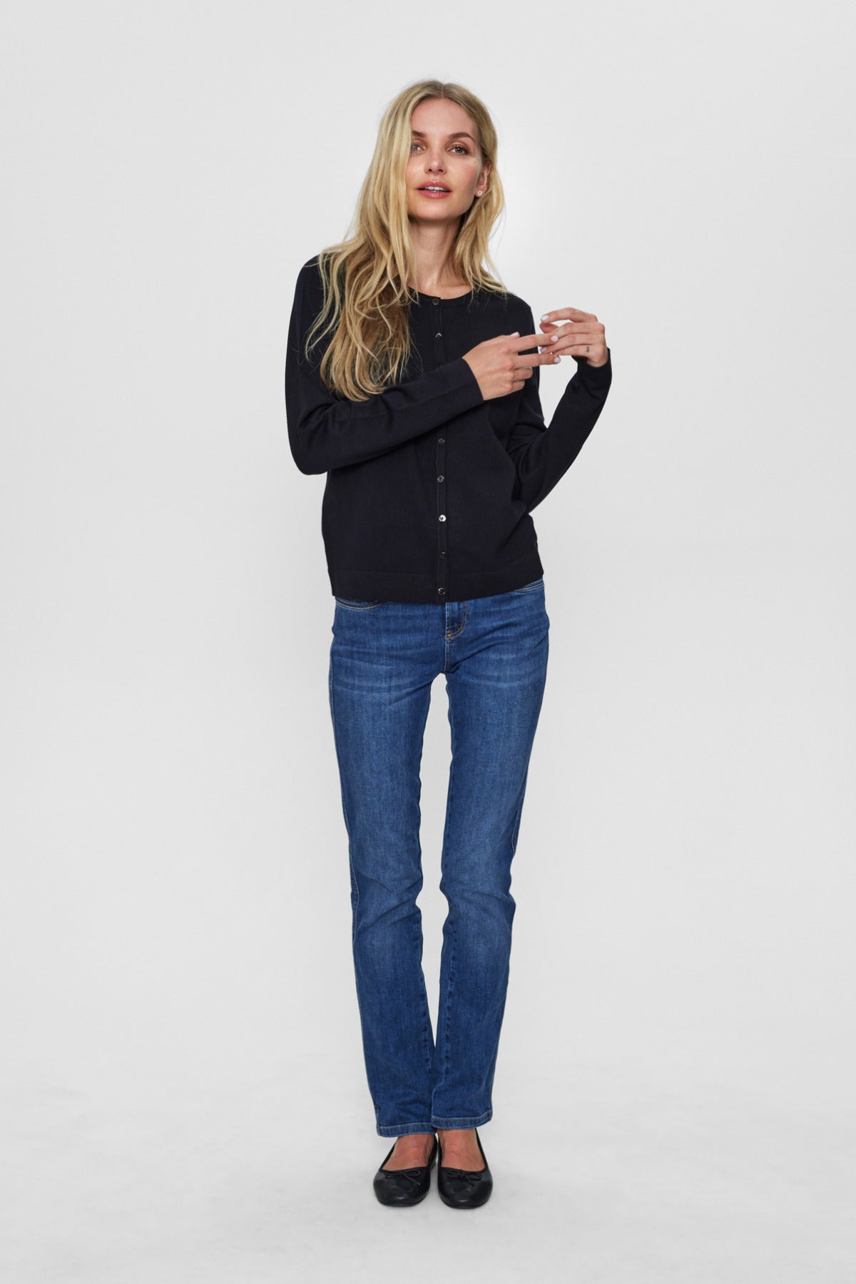 Kvinde stylet i sort cardigan og blå jeans