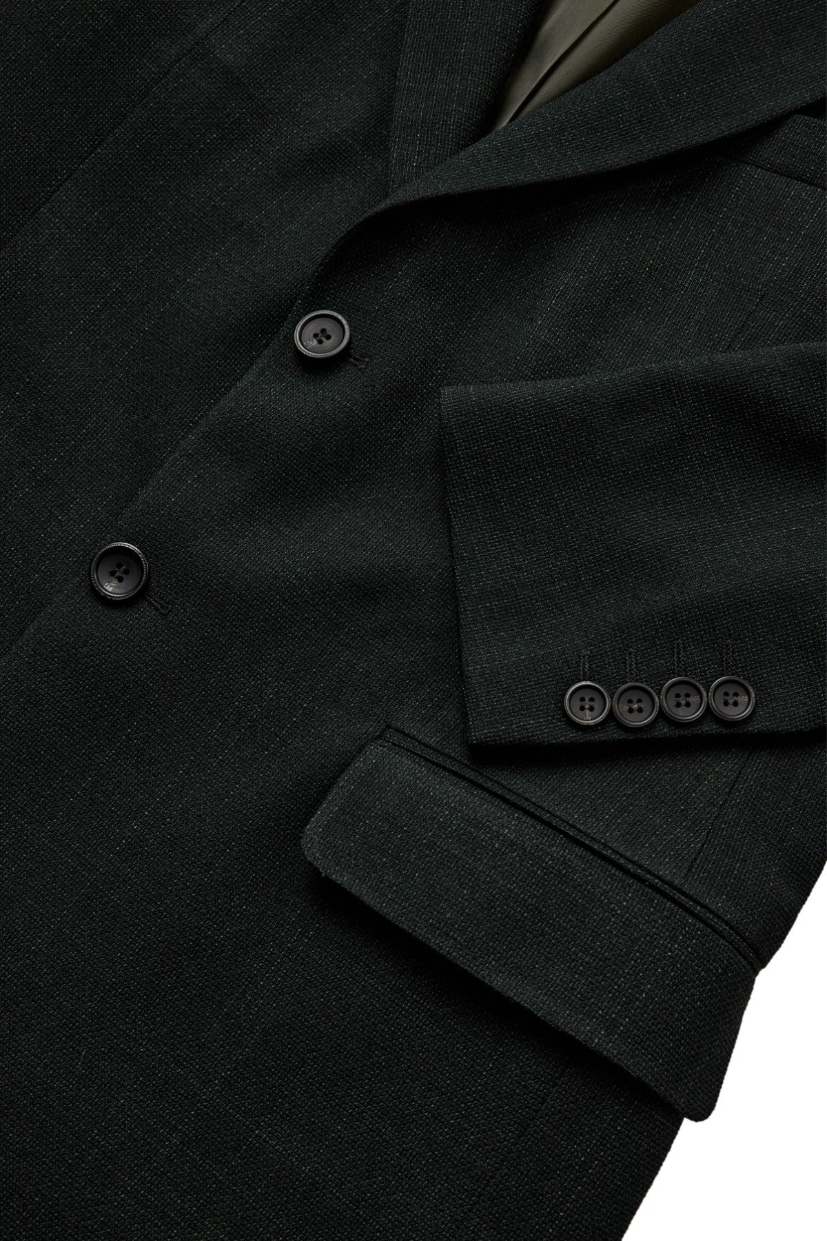 Sort uldblandet blazer med knapper og flapper på ærmer og lomme.