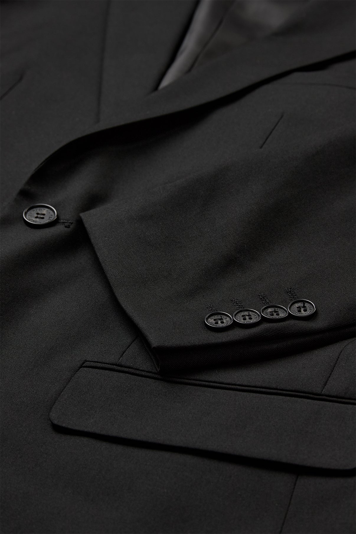 Sort klassisk blazer med knapper på ærme og enkeltstående frontknap.