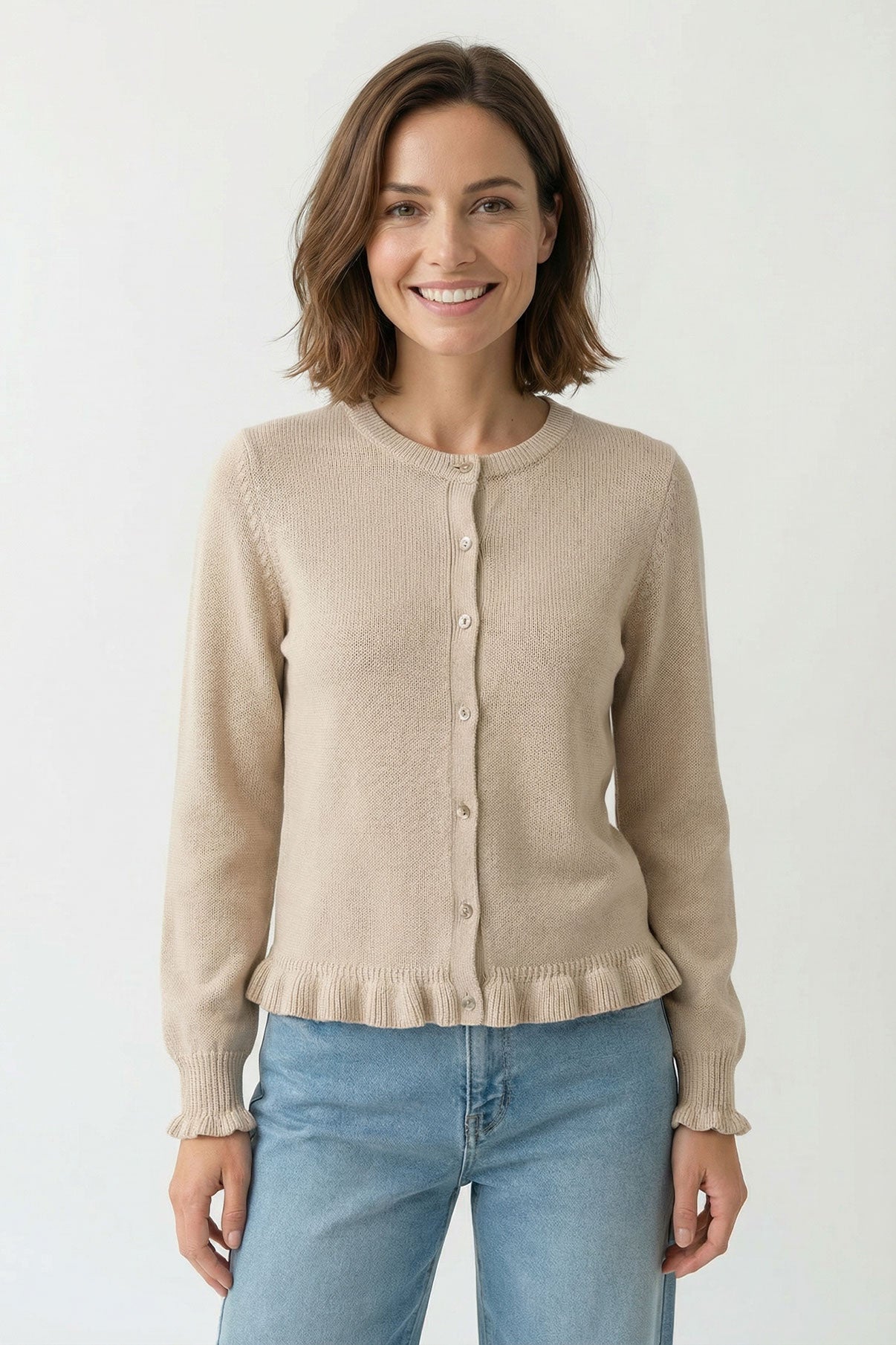 Beige strikcardigan med knapper og flæsekant i bunden, afslappet pasform.