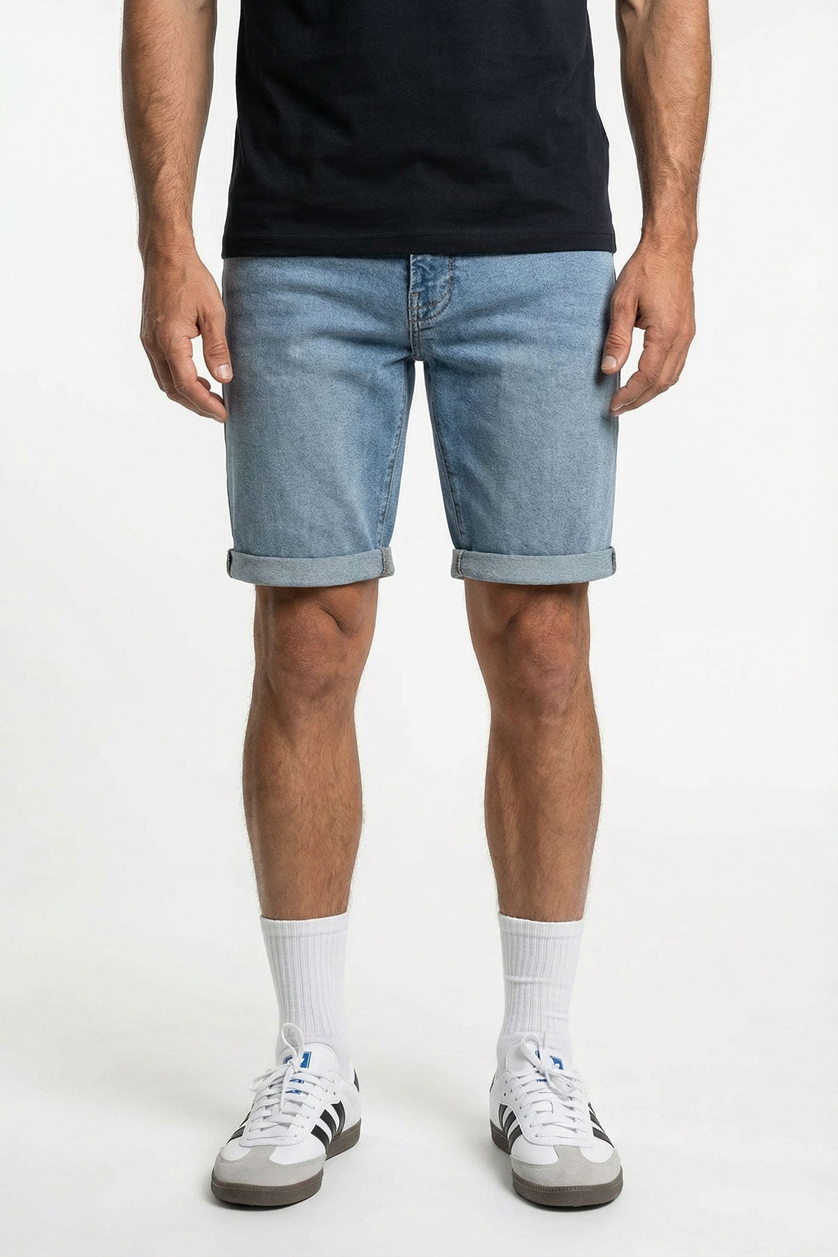 Blå denimshorts med optrukne kanter og let vasket finish, set forfra på model.