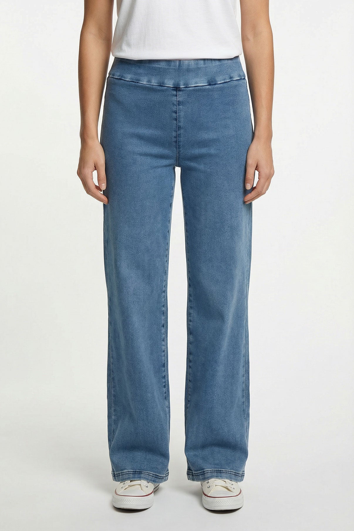Blå strækbare jeans med lige ben og høj talje, båret med hvid top og sneakers.