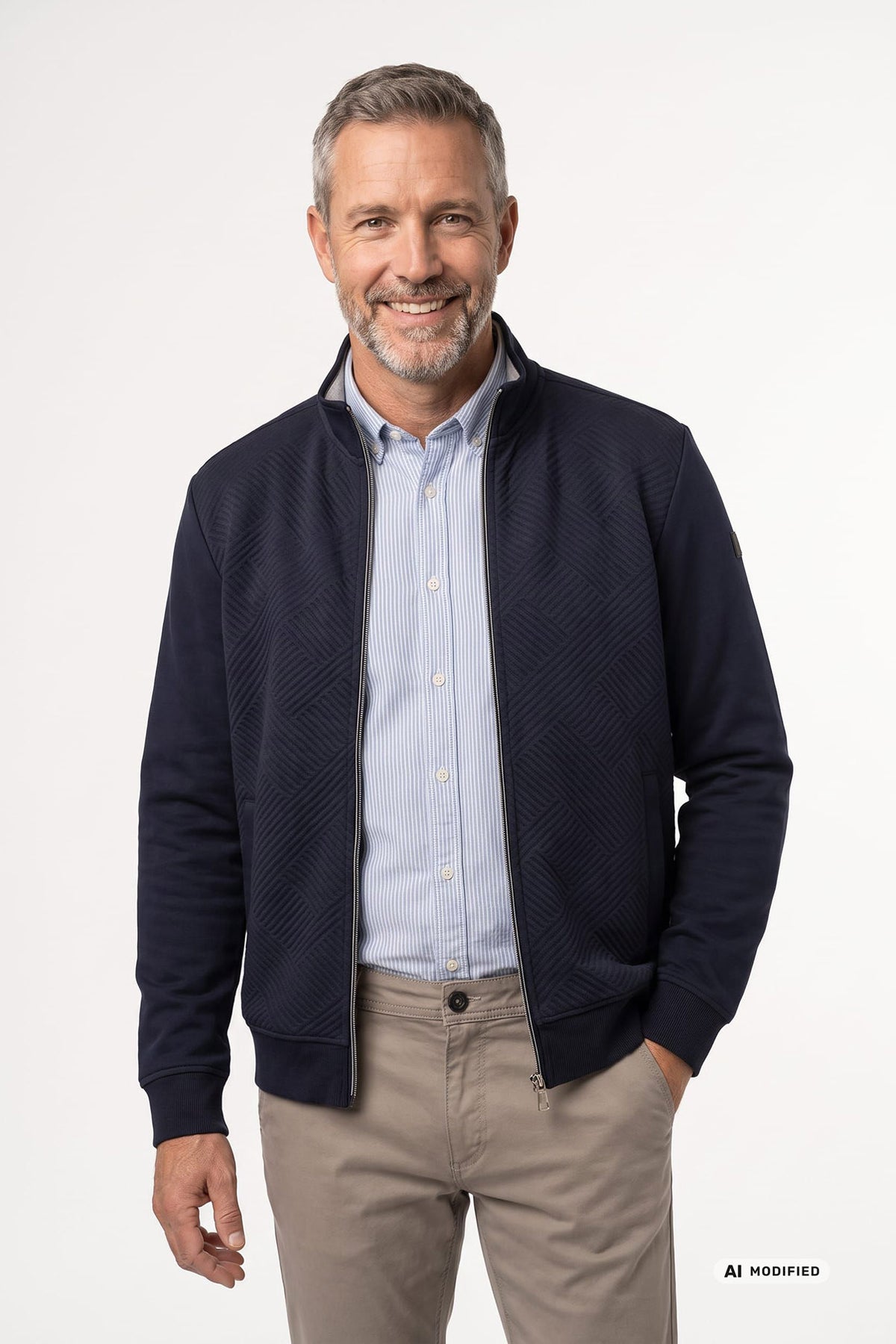 Mørkeblå sweatshirt med lynlås og strukturmønster over lyseblå skjorte, stylet med beige bukser.