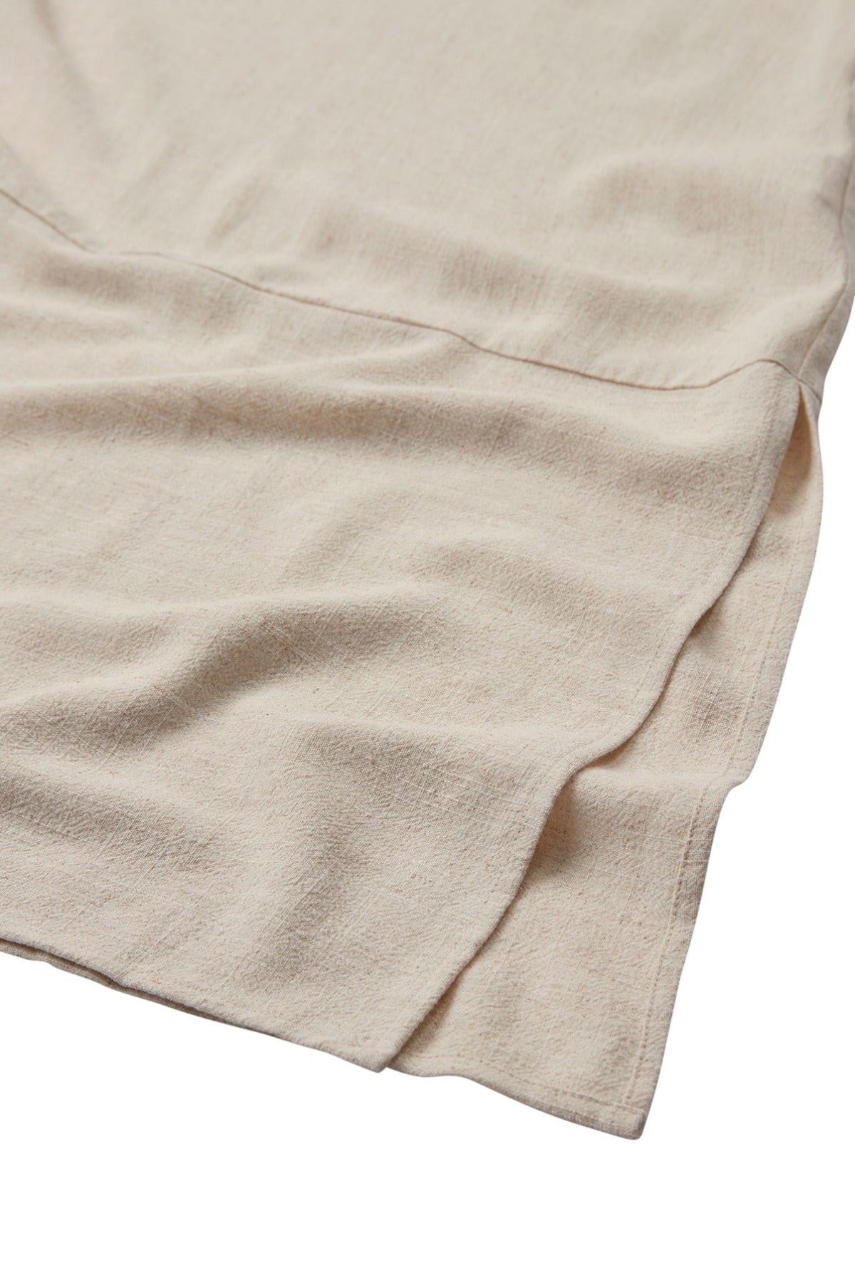 Detaljeret nærbillede af lys beige hørblanding med bløde tekstur og fin sømfinish.