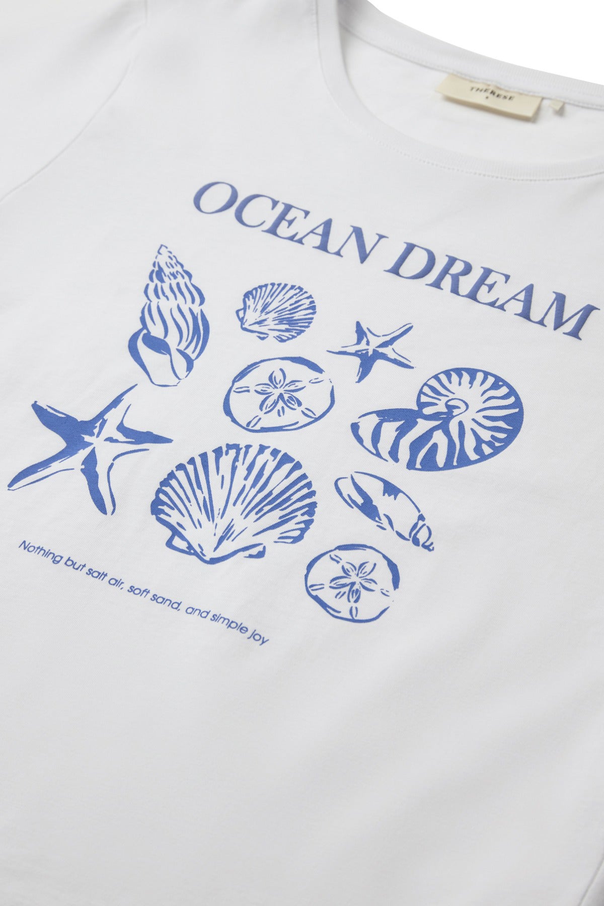 Hvid bomulds t-shirt med blå skaldyr og stjerne motiv samt teksten Ocean Dream foran.