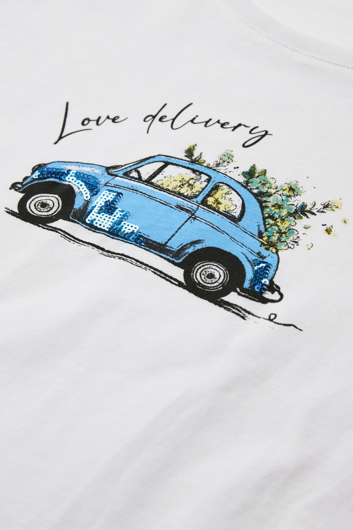 Hvid bomulds t-shirt med blå vintagebil og teksten "Love delivery" samt blomsterudsmykning.