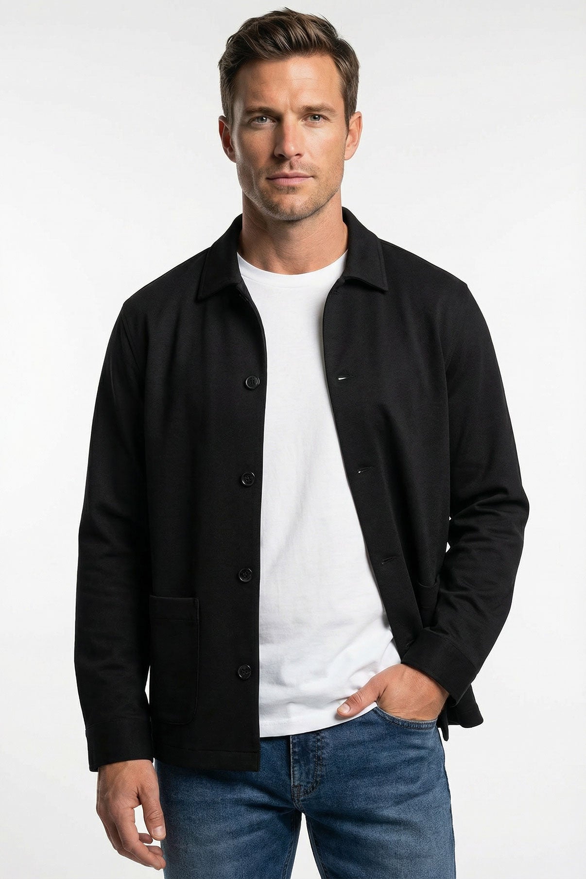 Sort strækbar overshirt med frontlommer og skjult knaplukning over hvid t-shirt.
