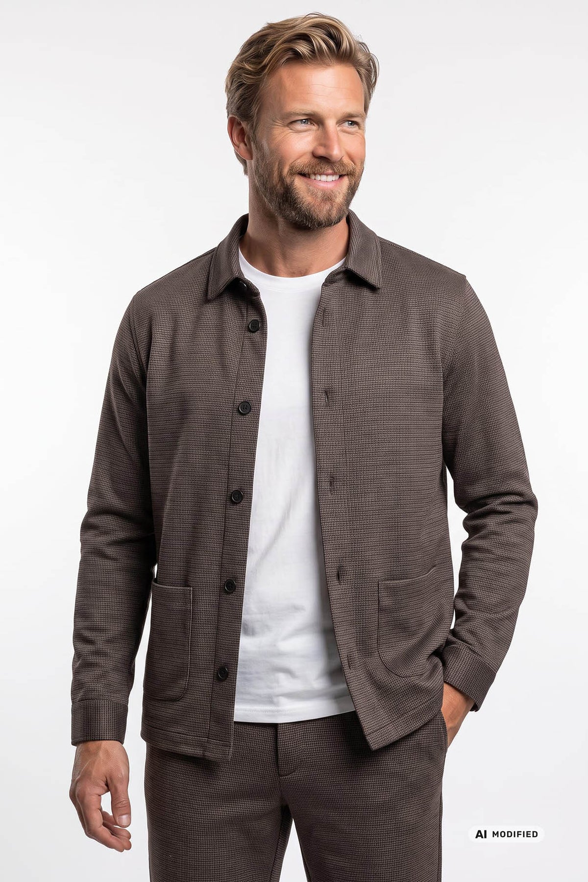 Brun overshirt i blødt stof med knapper og to fremtrædende lommer foran, båret over hvid t-shirt.