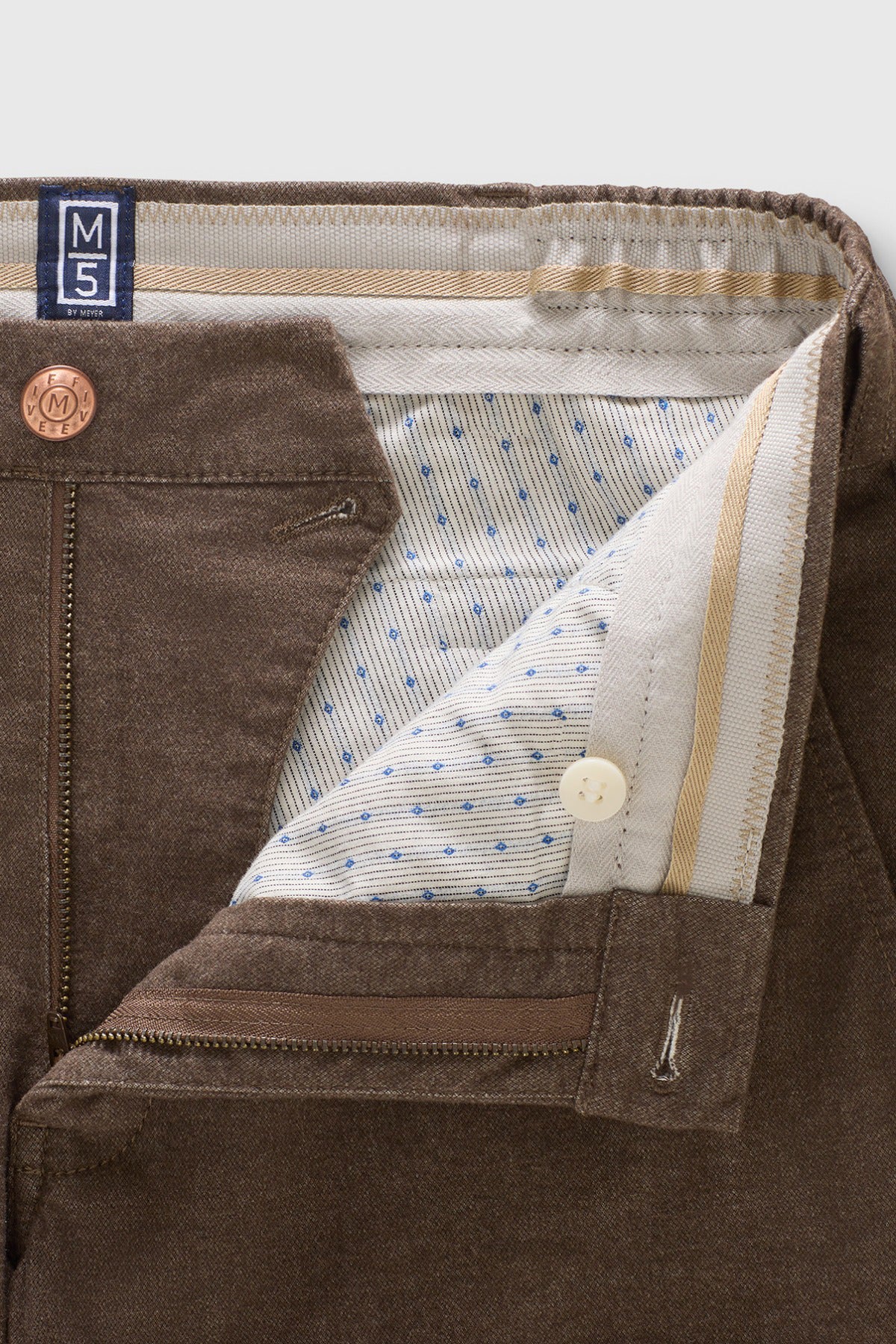 Brune flannel chinos med stretch, syninger, knaplukning og mønstret foring i taljen.