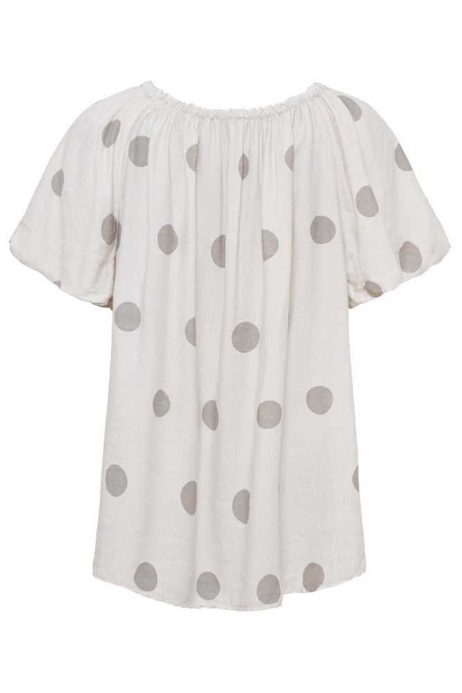 Beige kortærmet bluse i viskose med elastisk bådudskæring og store præget prikker.
