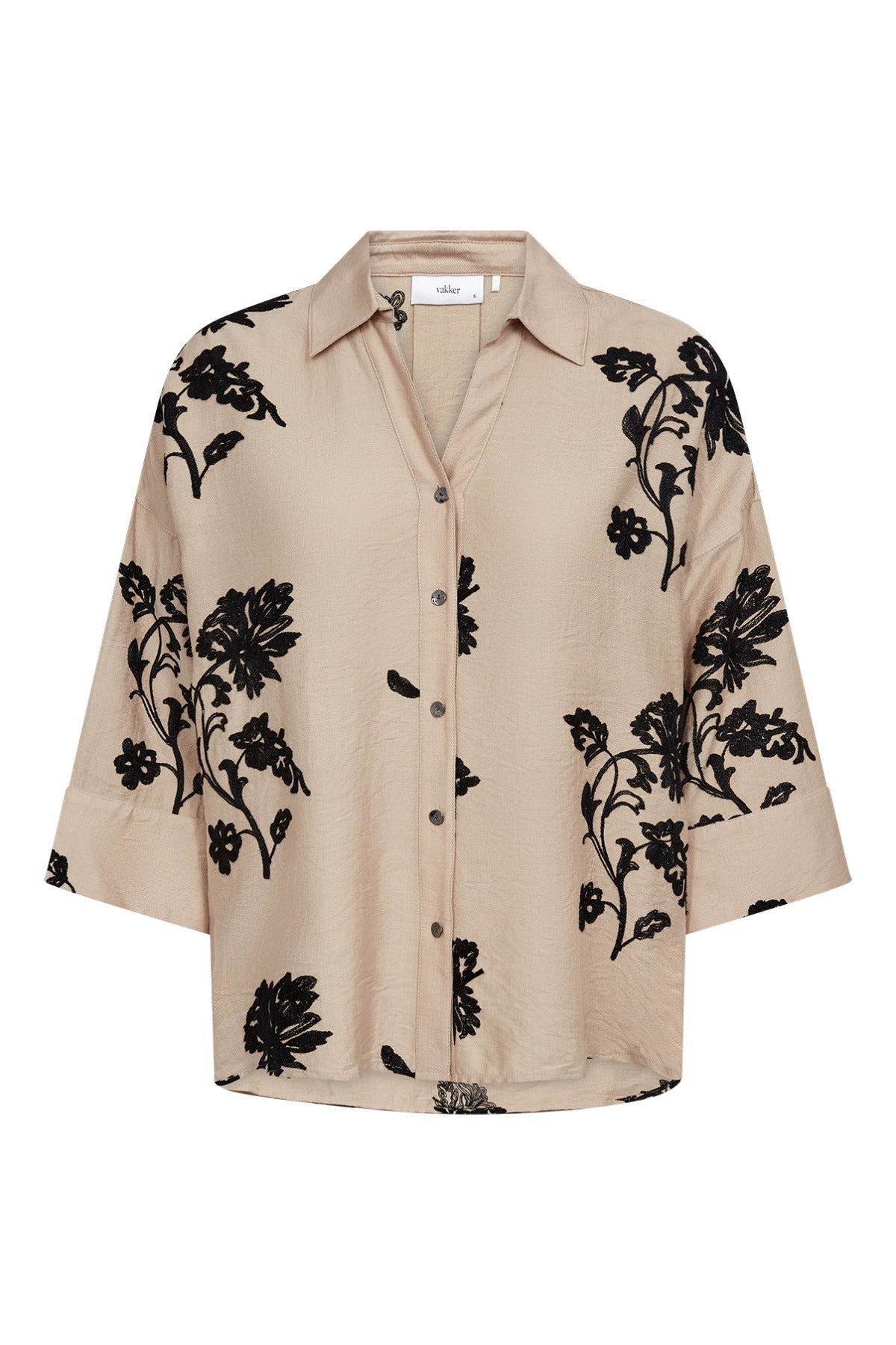 Beige skjortebluse med trekvartærmer og sort blomsterprint, løs pasform, knapper foran.