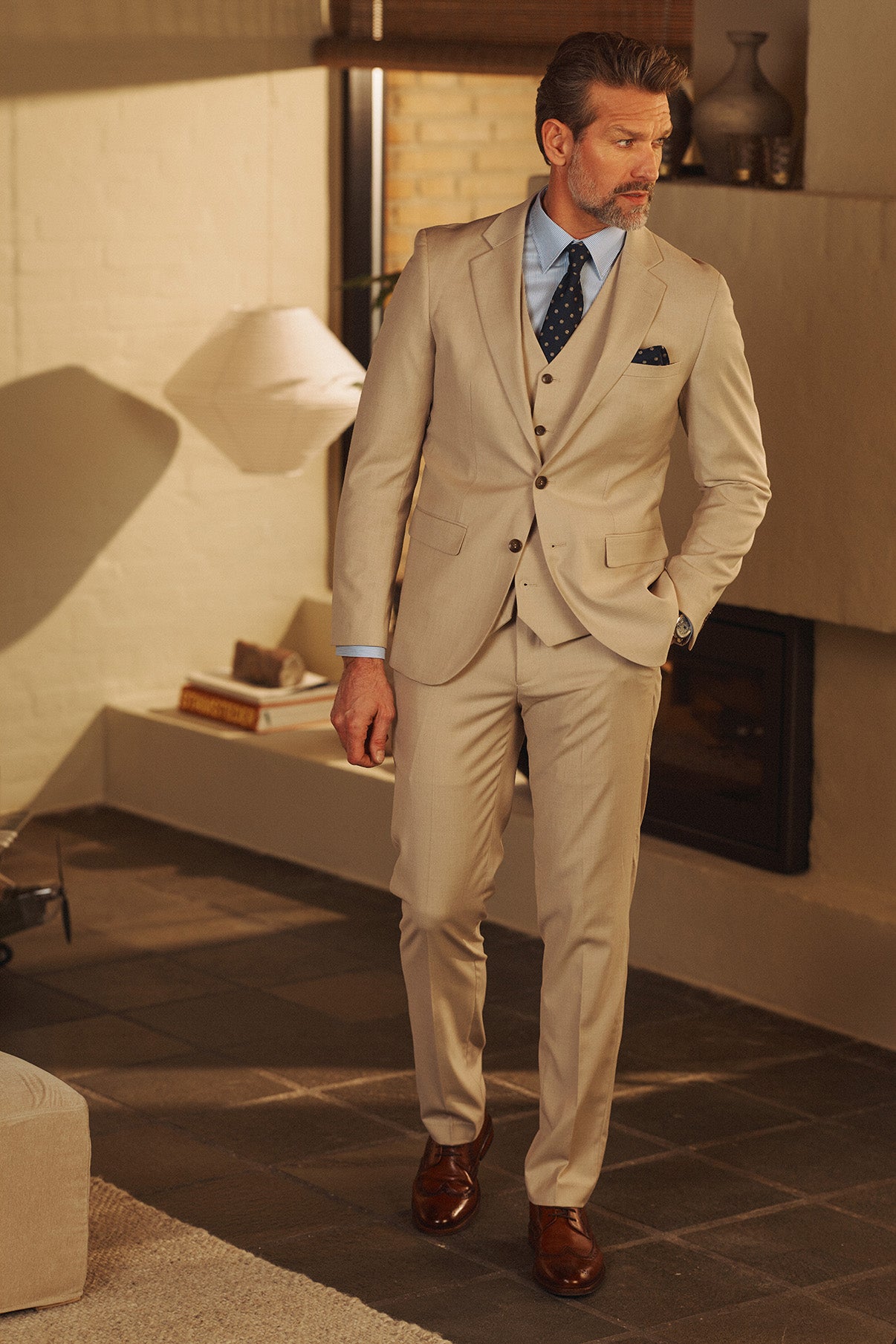 Klassiske beige bukser med pressefolder, smal pasform, stylet med beige blazer og brune sko.