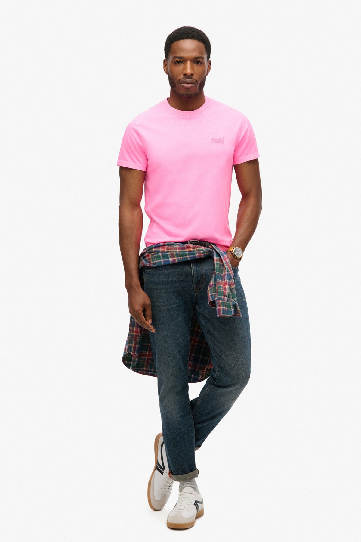 Lyserød neon t-shirt med rund hals og lille logo på brystet, mørkeblå jeans og skjorte bundet om livet.