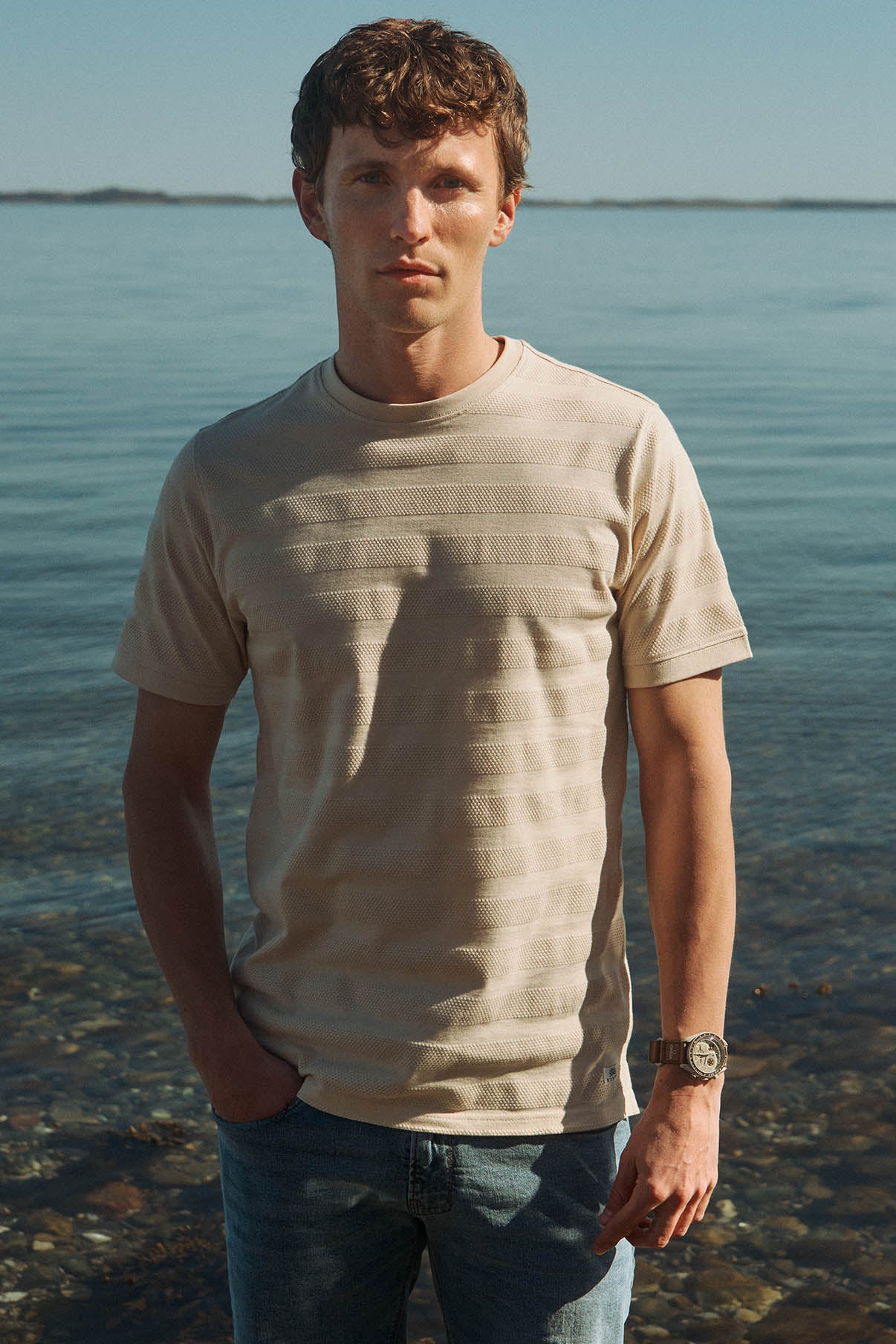 Beige kortærmet t-shirt med strukturstriber i let, åndbart stof, afslappet pasform.