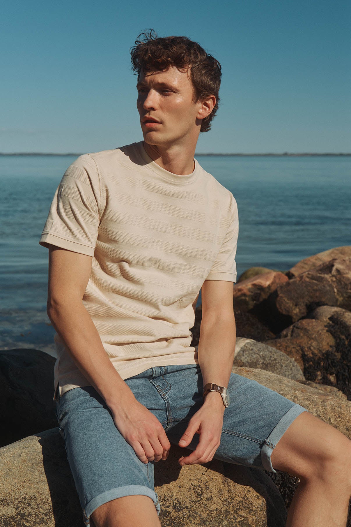 Kortærmet beige T-shirt med strukturstriber, rund hals, afslappet pasform.