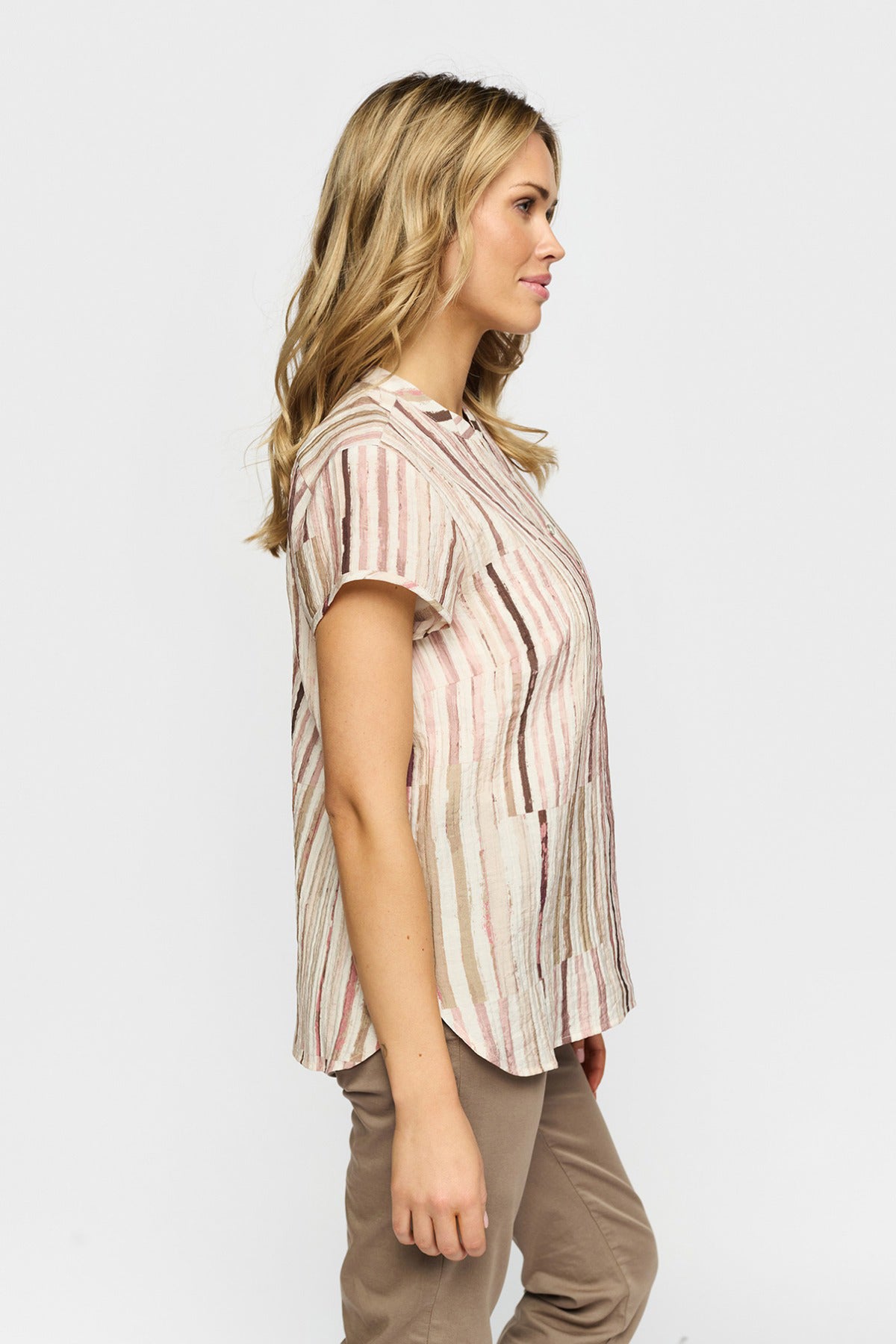 Kortærmet bluse med rosa og hvide lodrette striber og løs pasform set fra siden.