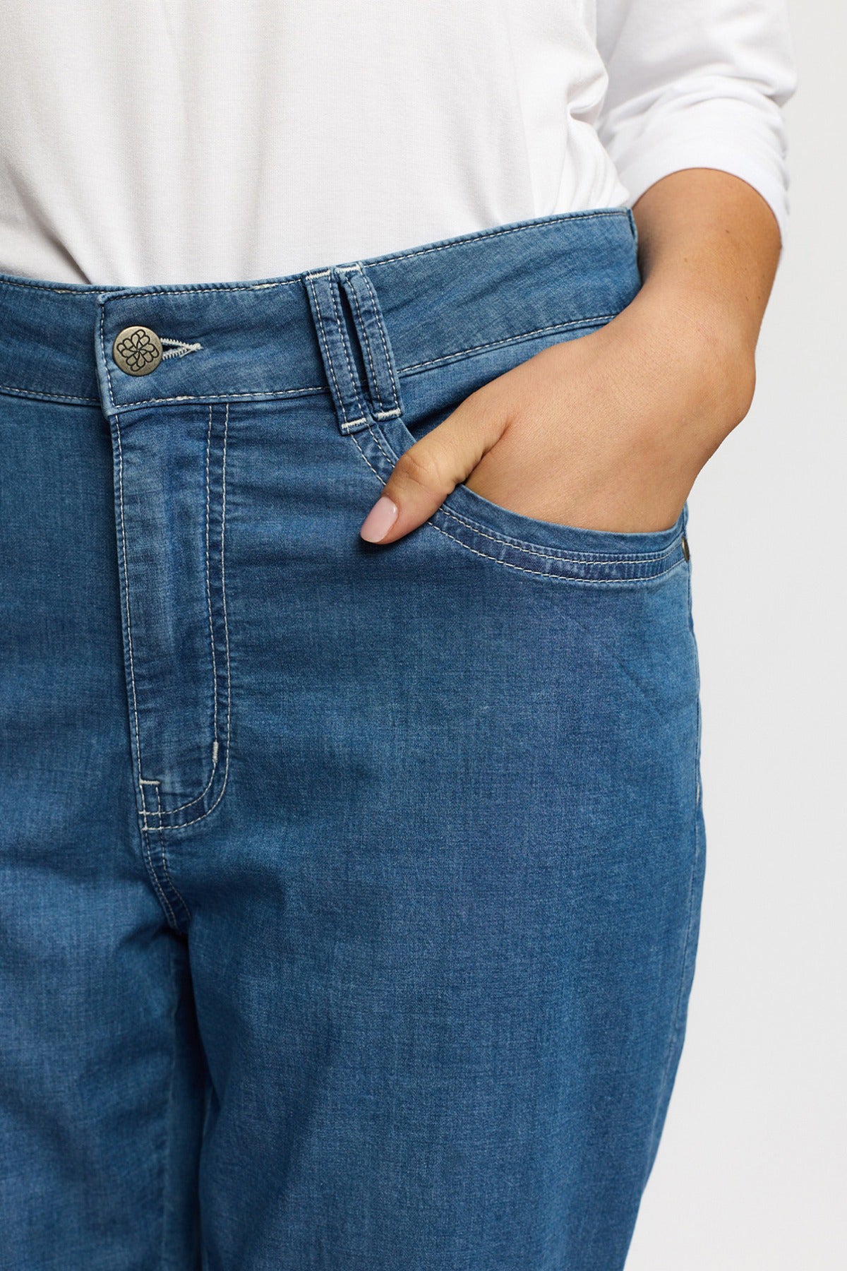 Blå strækbare capri bukser i denim med knappelukning og lommer foran.