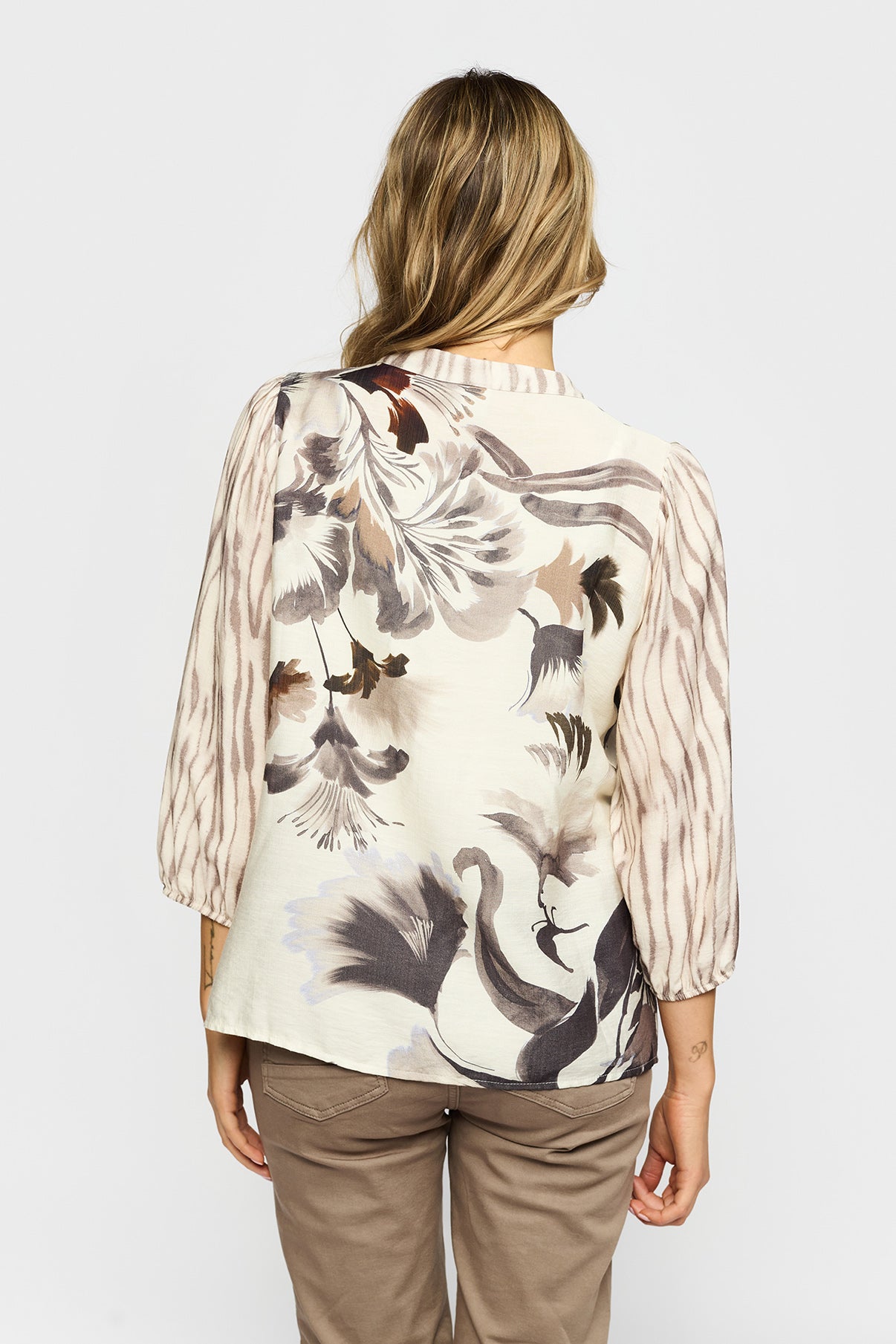 Bluse med beige og brune blomsterprint og trekvartærmer i let transparent stof.