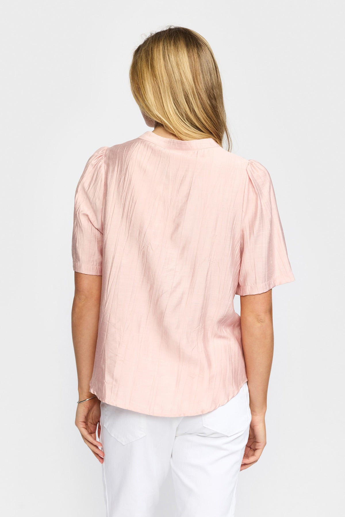 Lyserød kortærmet bluse med rund hals og blondedetalje, set bagfra.