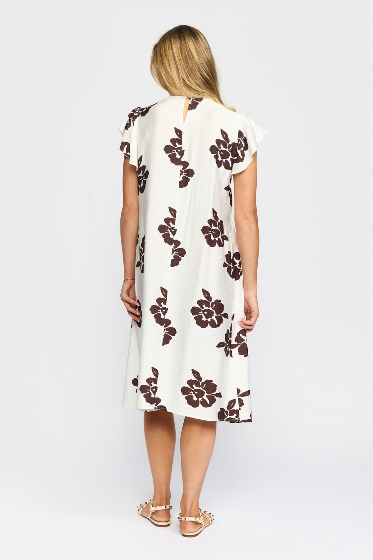 Hvid kortærmet kjole med brune blomsterprint og knælang pasform set bagfra.