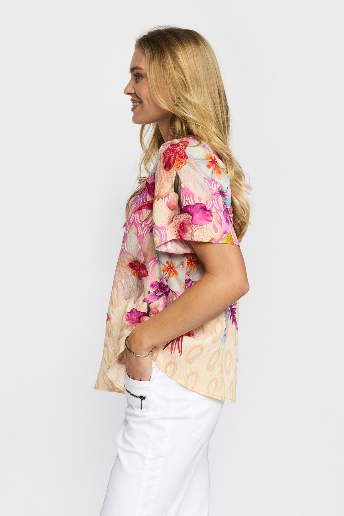 Kortærmet bluse med blomsterprint i pink og røde toner, beige bundfarve og rund hals.