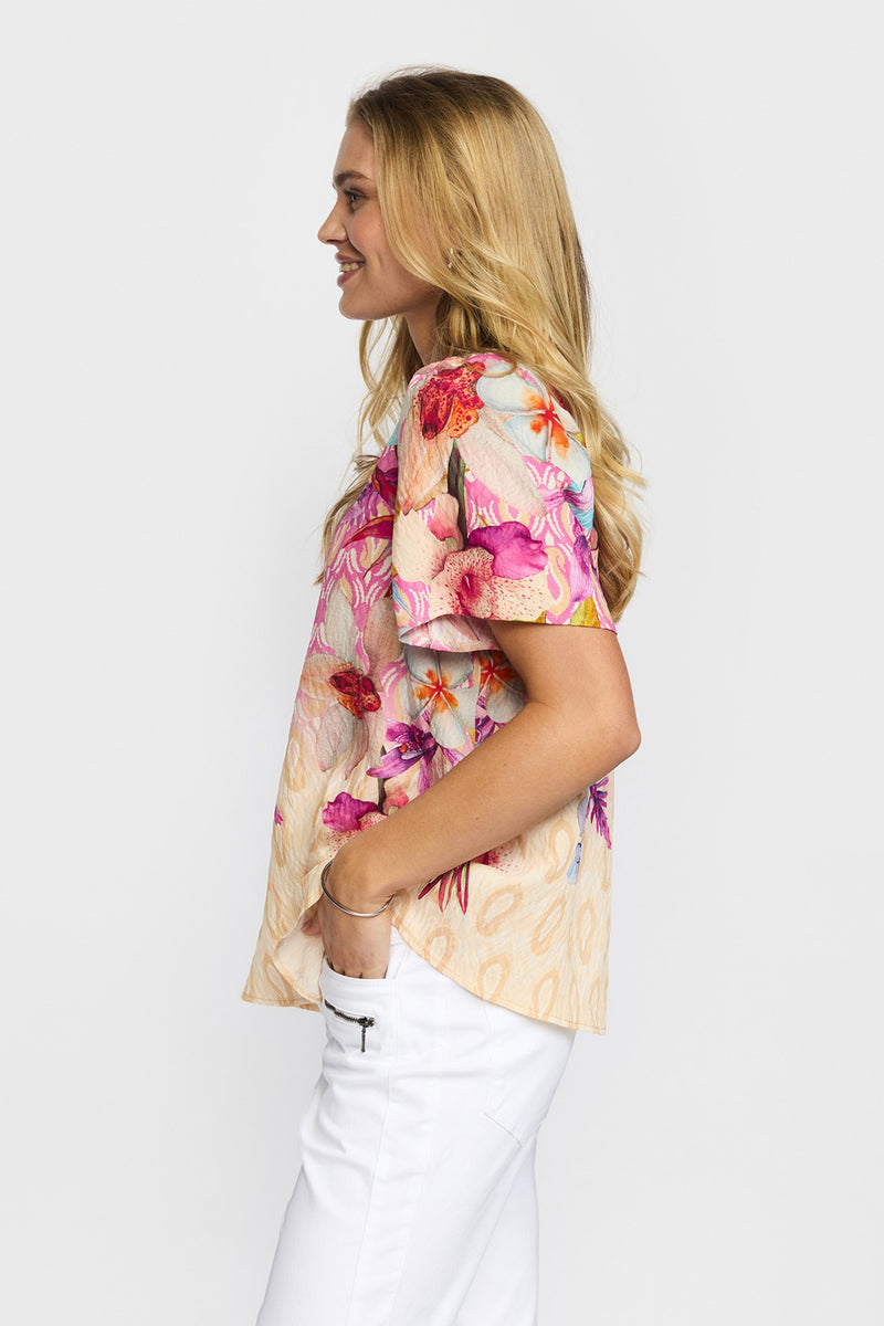 Kortærmet bluse med blomsterprint i pink og røde toner, beige bundfarve og rund hals.