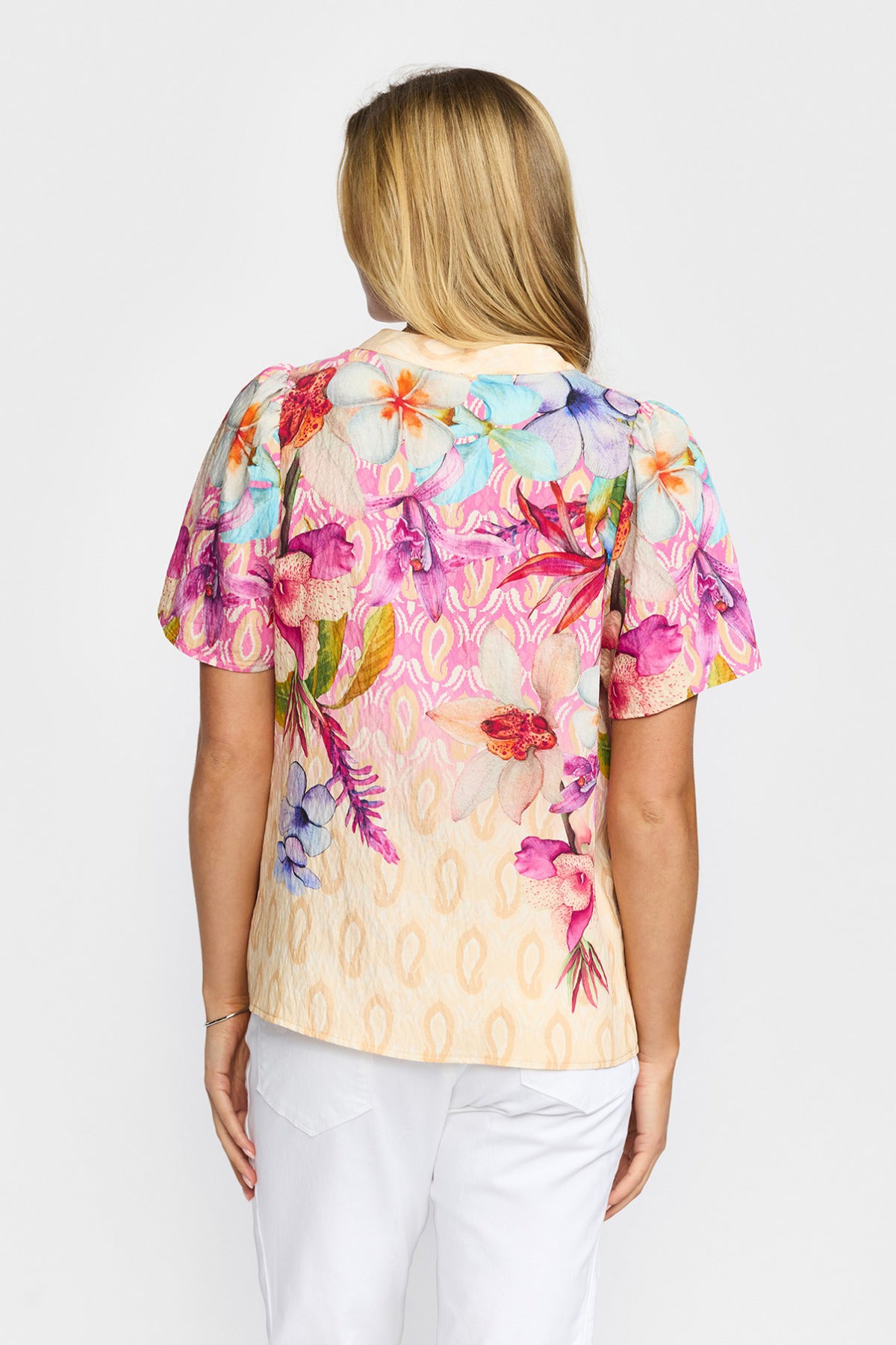 Kortærmet bluse med flerfarvet blomsterprint og let pufærmer, set bagfra.