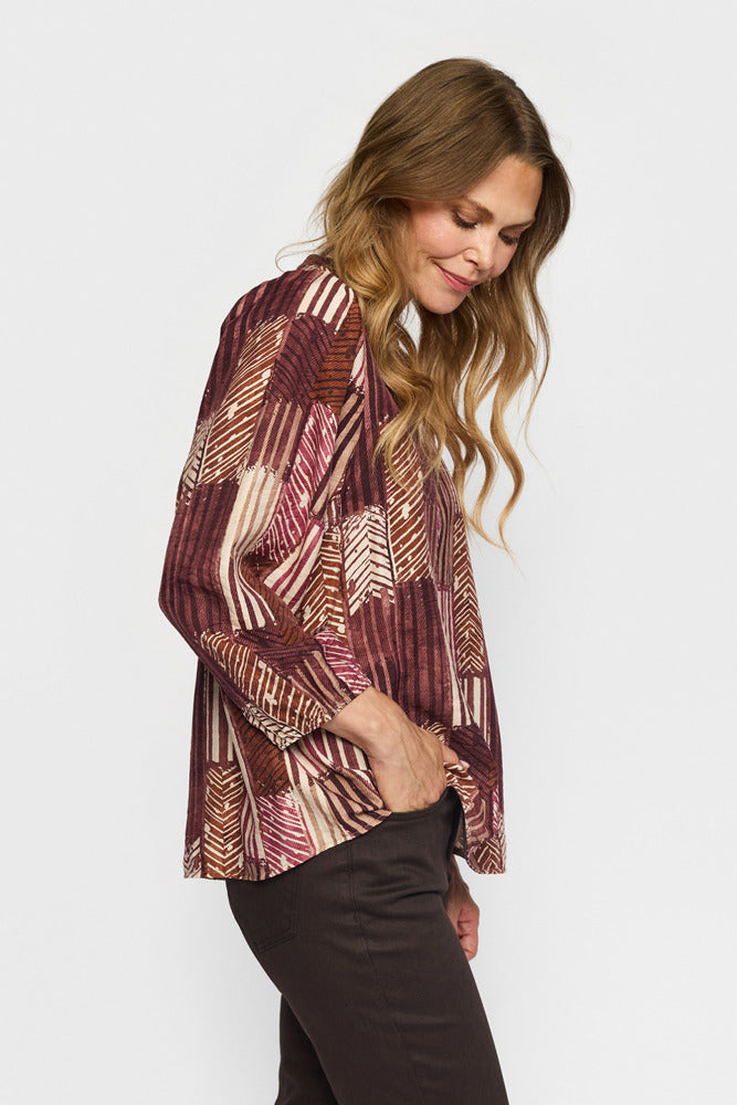 Mønstret bluse med v-hals i vinrød og beige stribet design, løs pasform og lange ærmer.