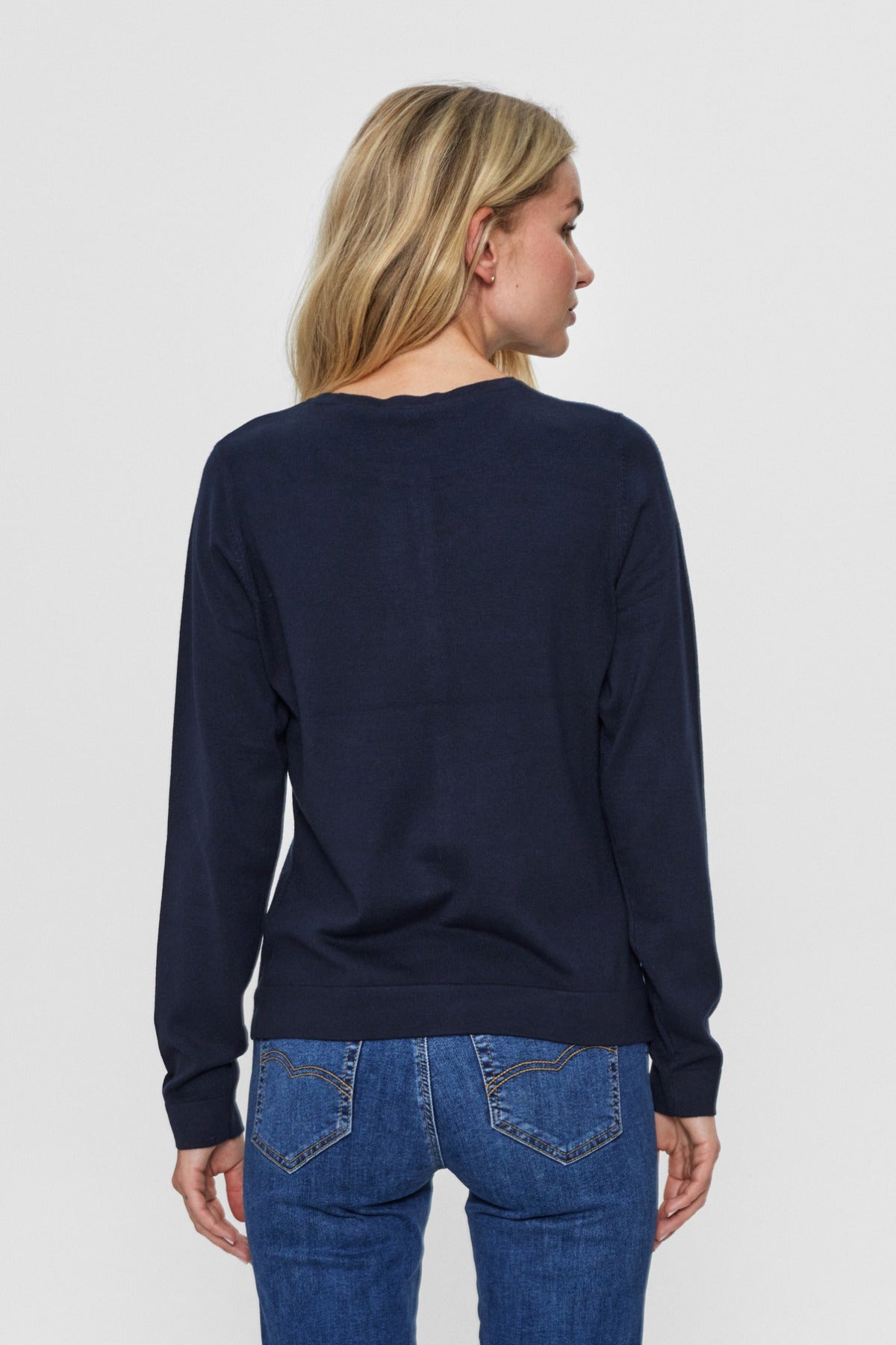 Kvinde med navy cadigan set bagfra