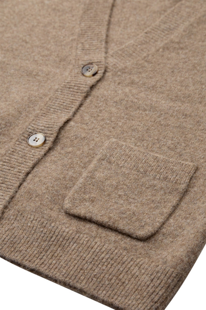 Strik cardigan i varm sand med knapper og lille frontlomme i blød uldkvalitet.