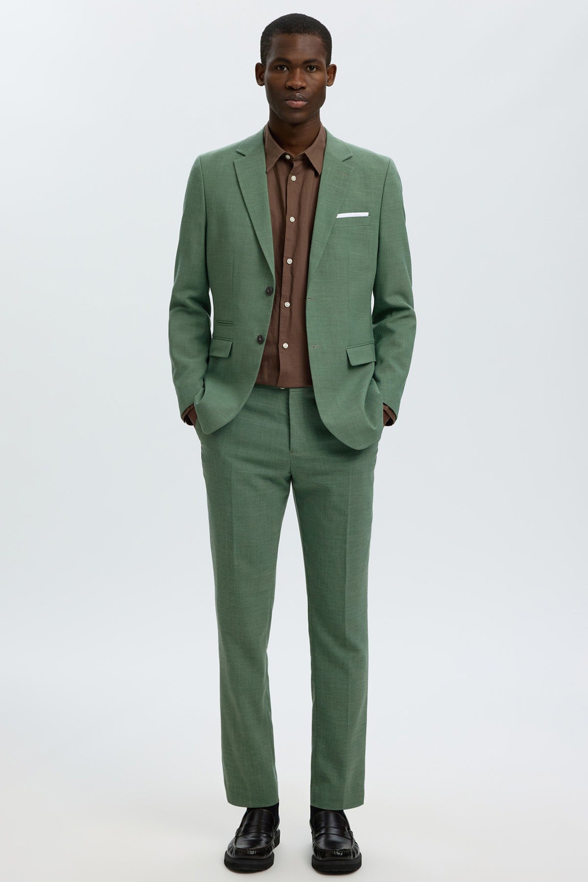 Oliven grøn slim-fit linnedbukser med nederste kant, stylet med matchende blazer og brun skjorte.