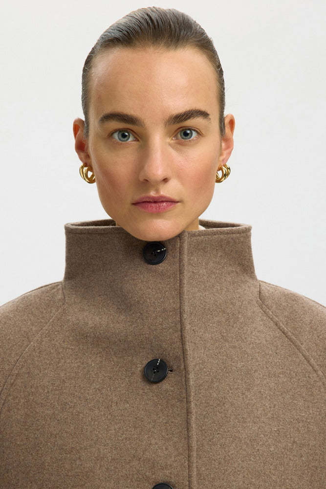 Lang uldfrakke i brun med høj krave og sorte knapper, minimalistisk design.