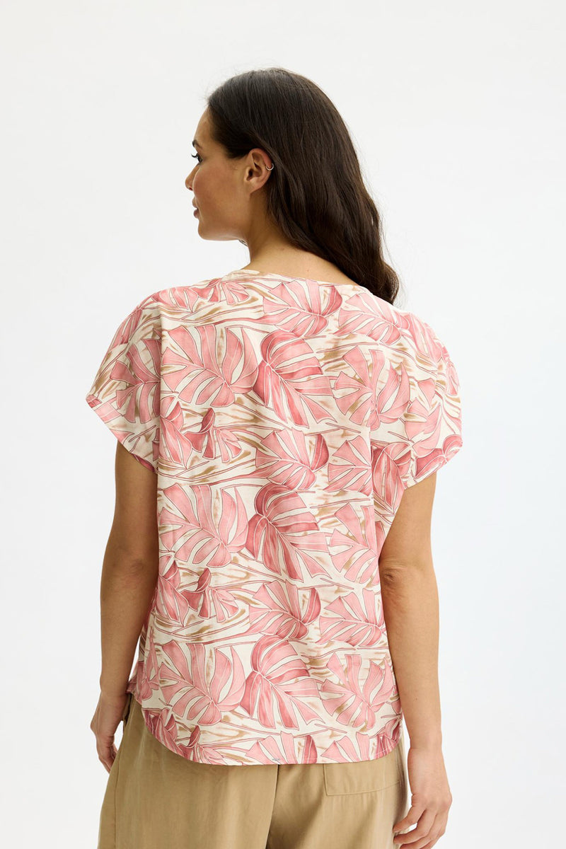 Løs rosa bluse med hvidt bølgemønster og korte ærmer set bagfra.