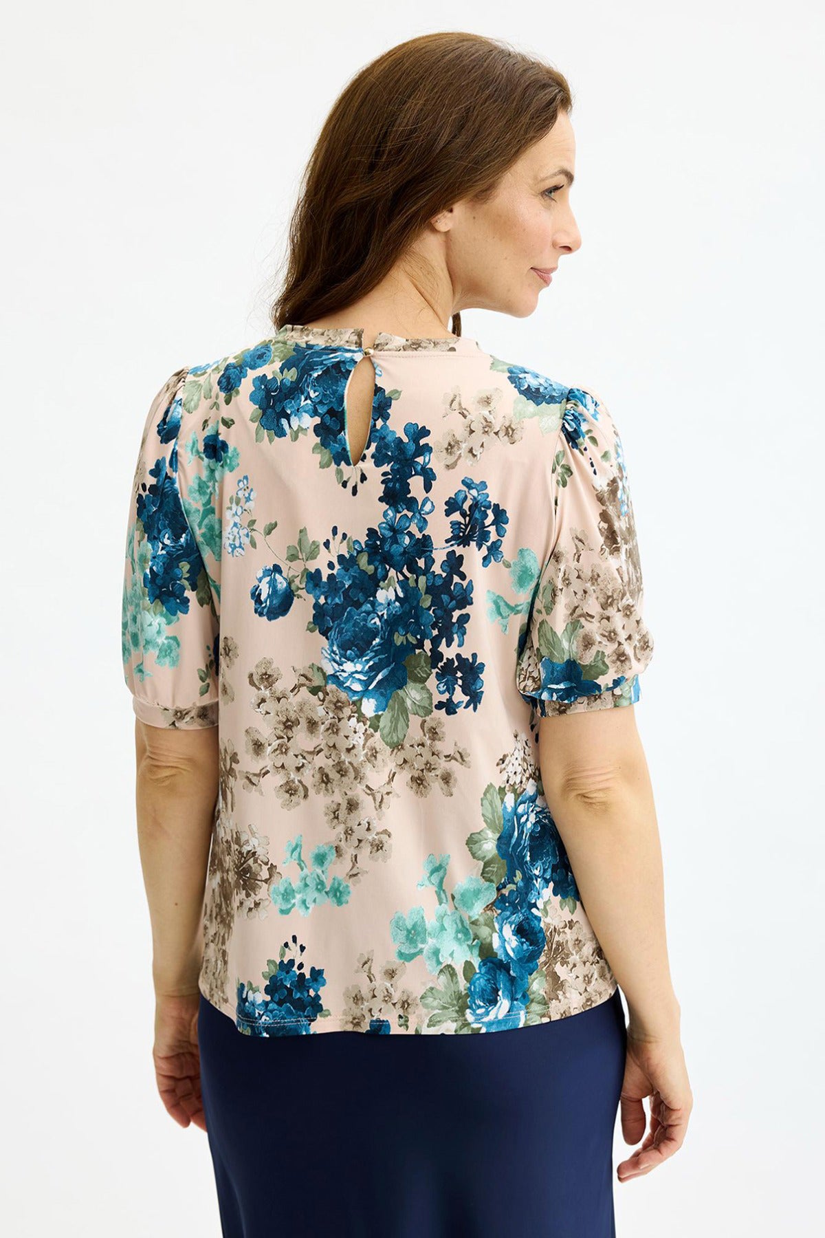 Soft rose bluse med blå blomsterprint og korte ærmer, set bagfra.