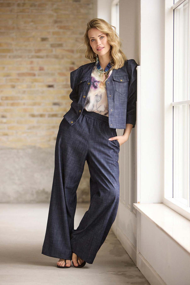 Let mørkeblå jakke med puffærmer i denimlook og matchende vide bukser.