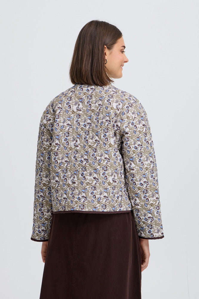 Let quiltet jakke med grønt og beige blomsterprint, rund hals og lige pasform set bagfra.