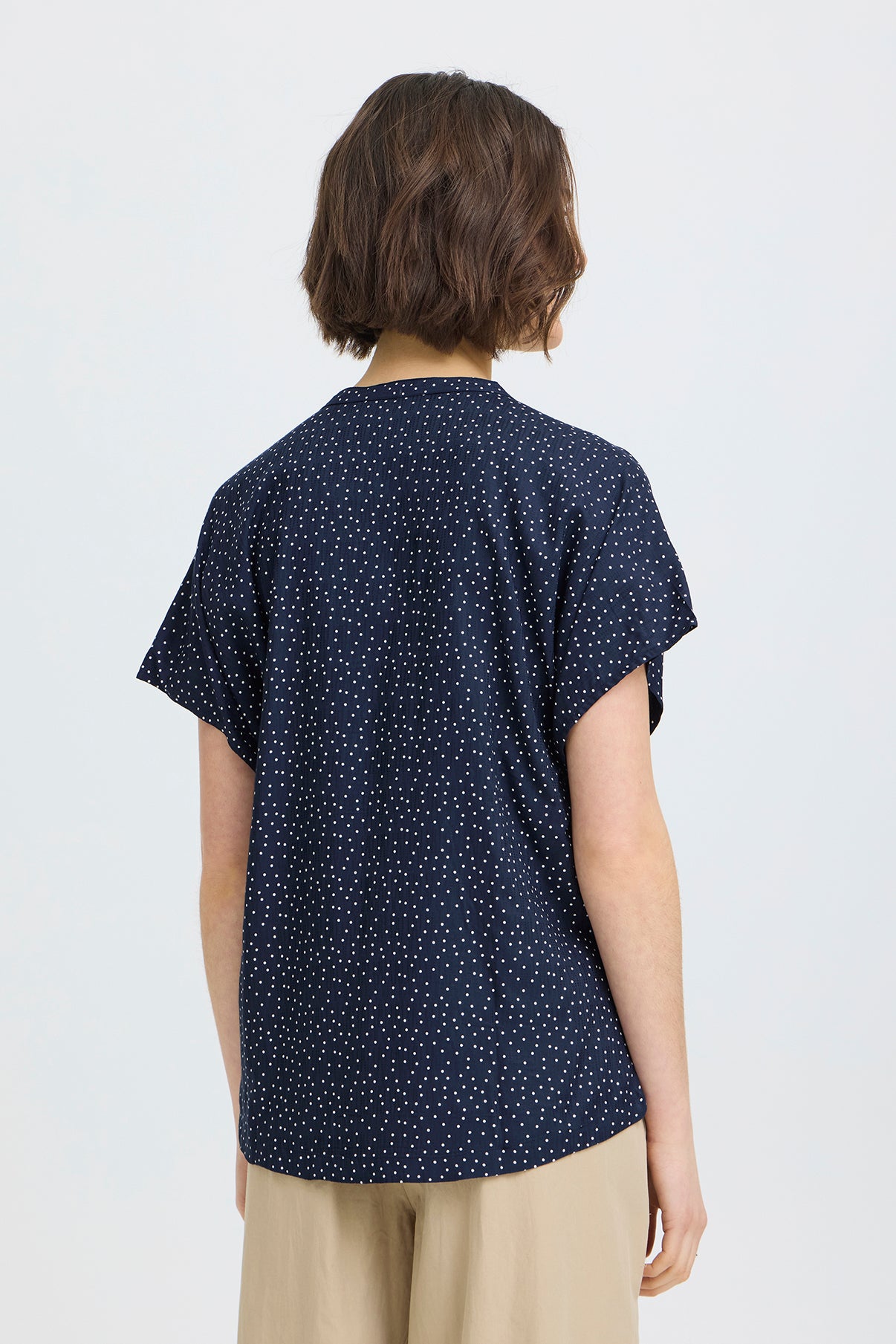 Navyblå kortærmet bluse med små hvide prikker i let oversized pasform set bagfra.