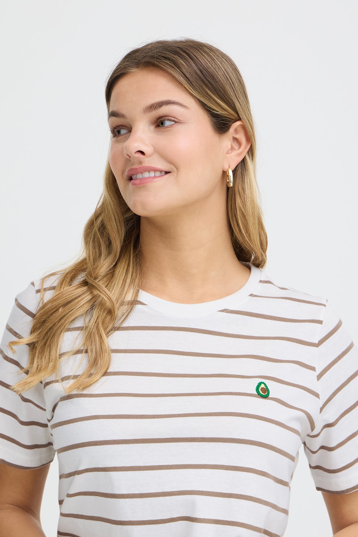 Hvid t-shirt med brune vandrette striber og lille broderet grøn detalje ved brystet.