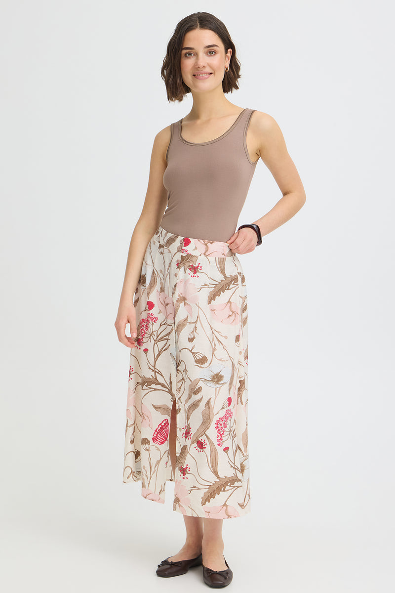 Lang lys nederdel med blomsterprint og slids, let og flowy design.