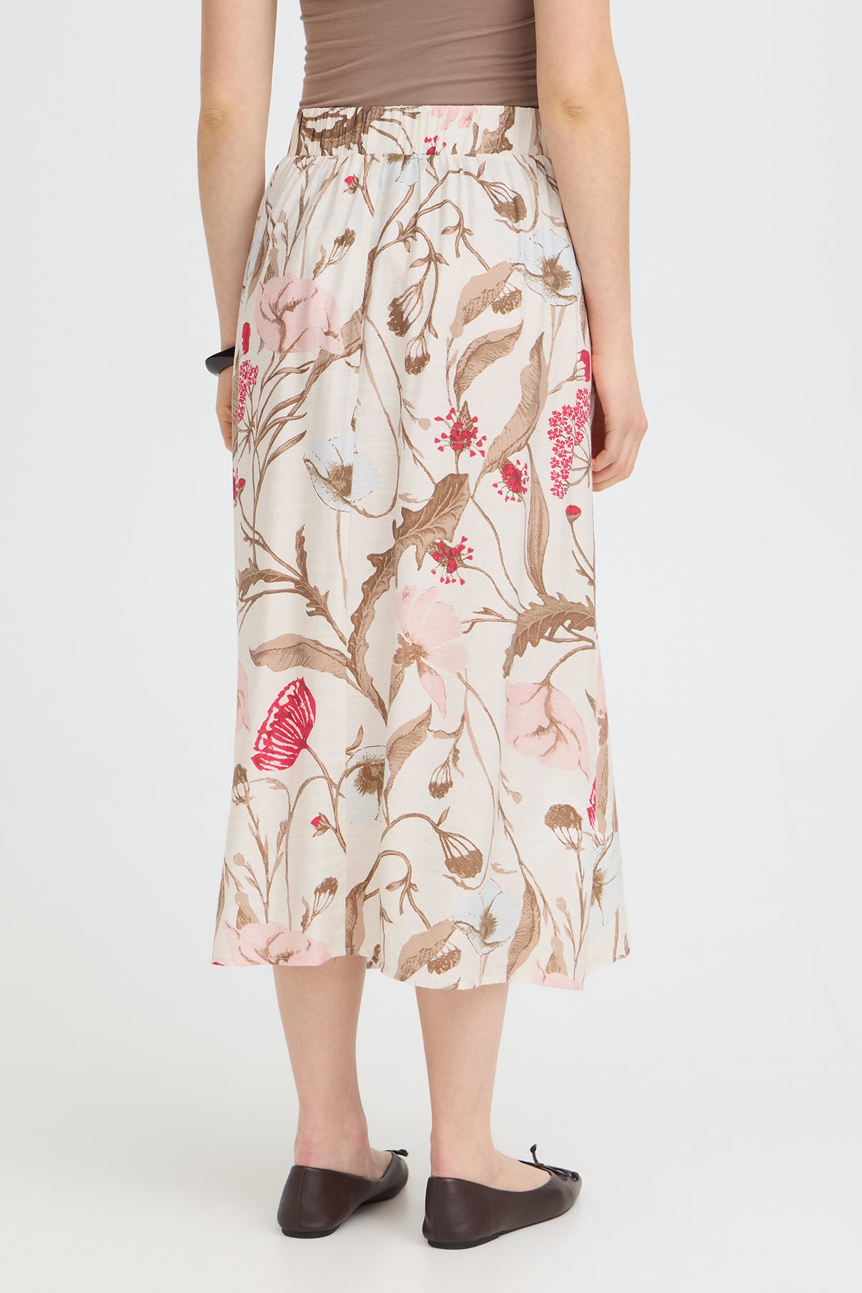 Lang nederdel med blomsterprint i beige, rosa og brune nuancer med slids bagpå.