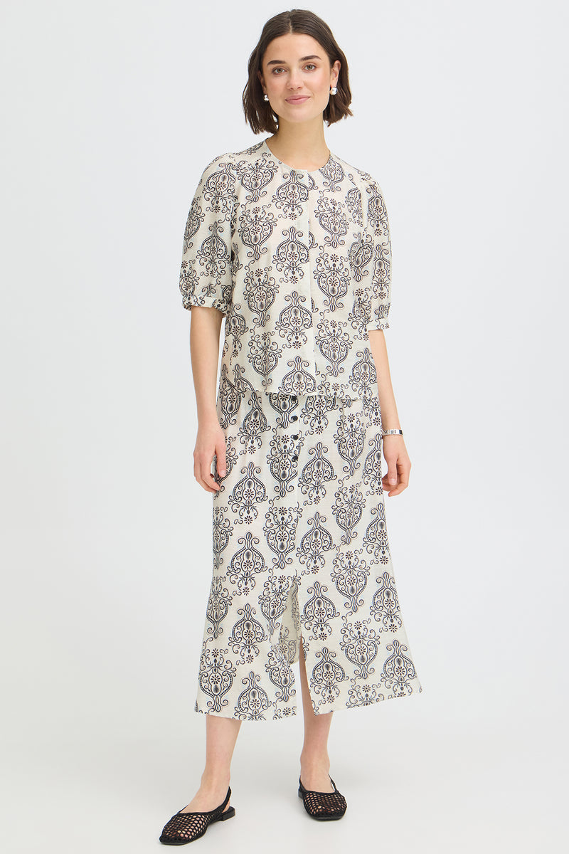 Kortærmet bluse med rund hals og sort-hvidt boho-mønster på hvid bund.