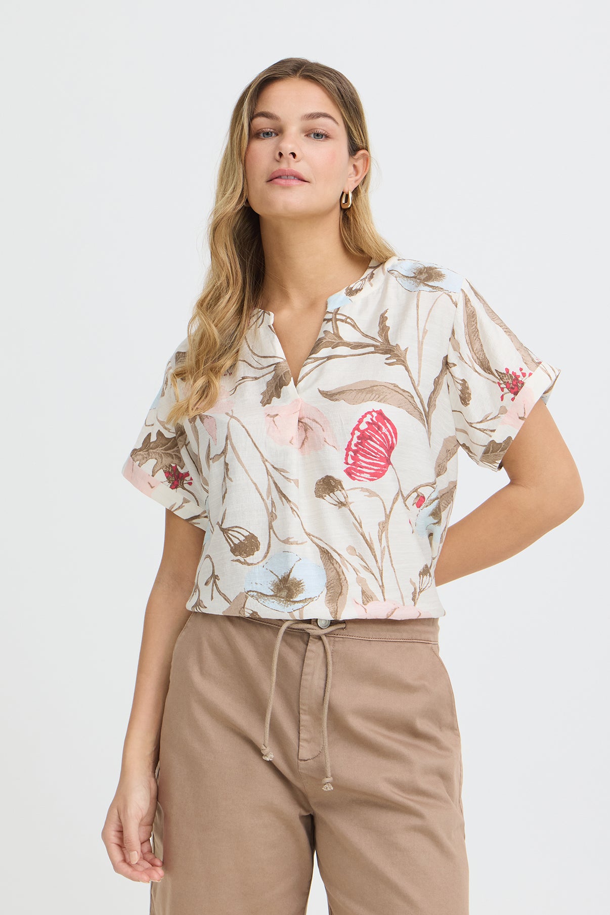 Kortærmet bluse med v-udskæring i hvid med beige og rosa blomsterprint.