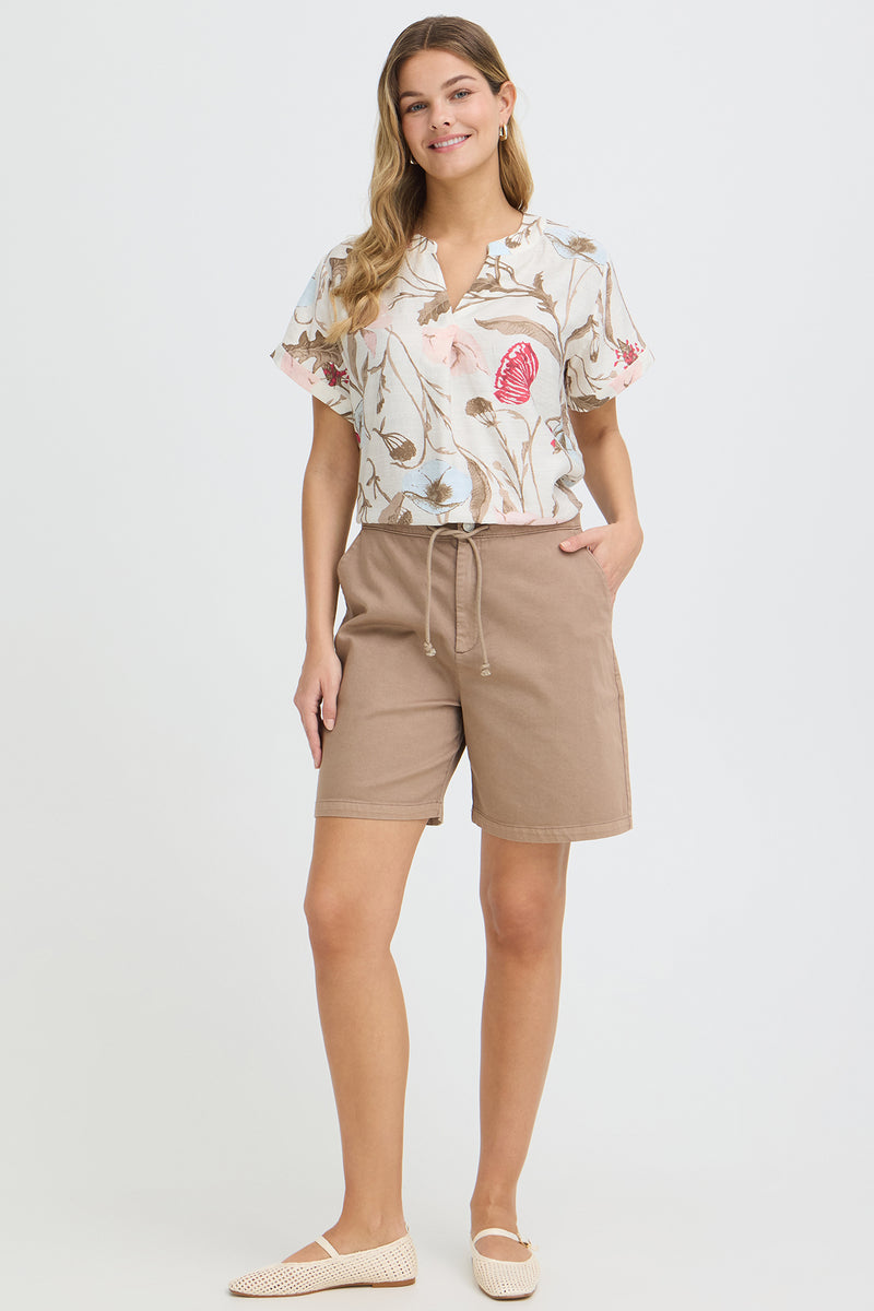 Kortærmet bluse med v-udskæring i hvid med blomsterprint i rød og beige nuancer.