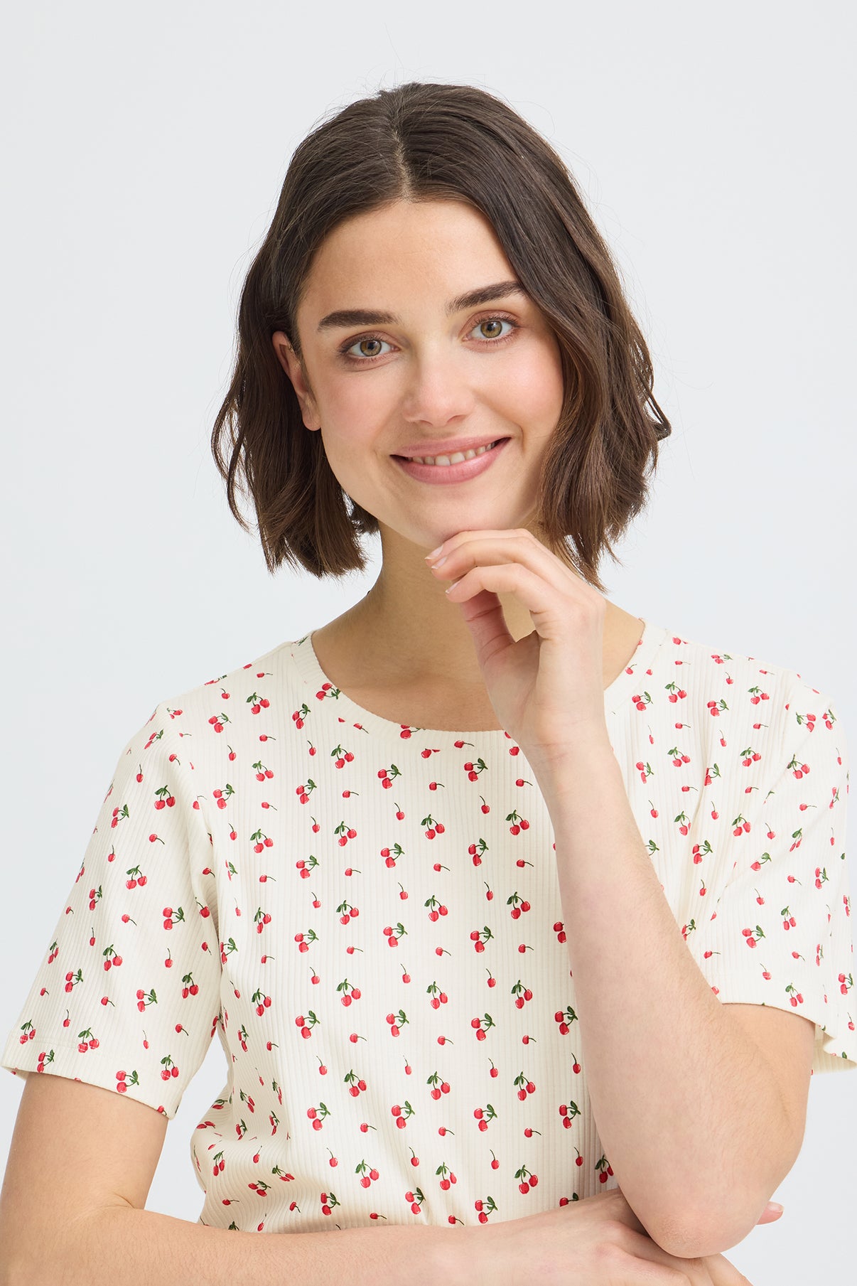 Kortærmet t-shirt i pastel gul med små kirsebærprint over hele stoffet.