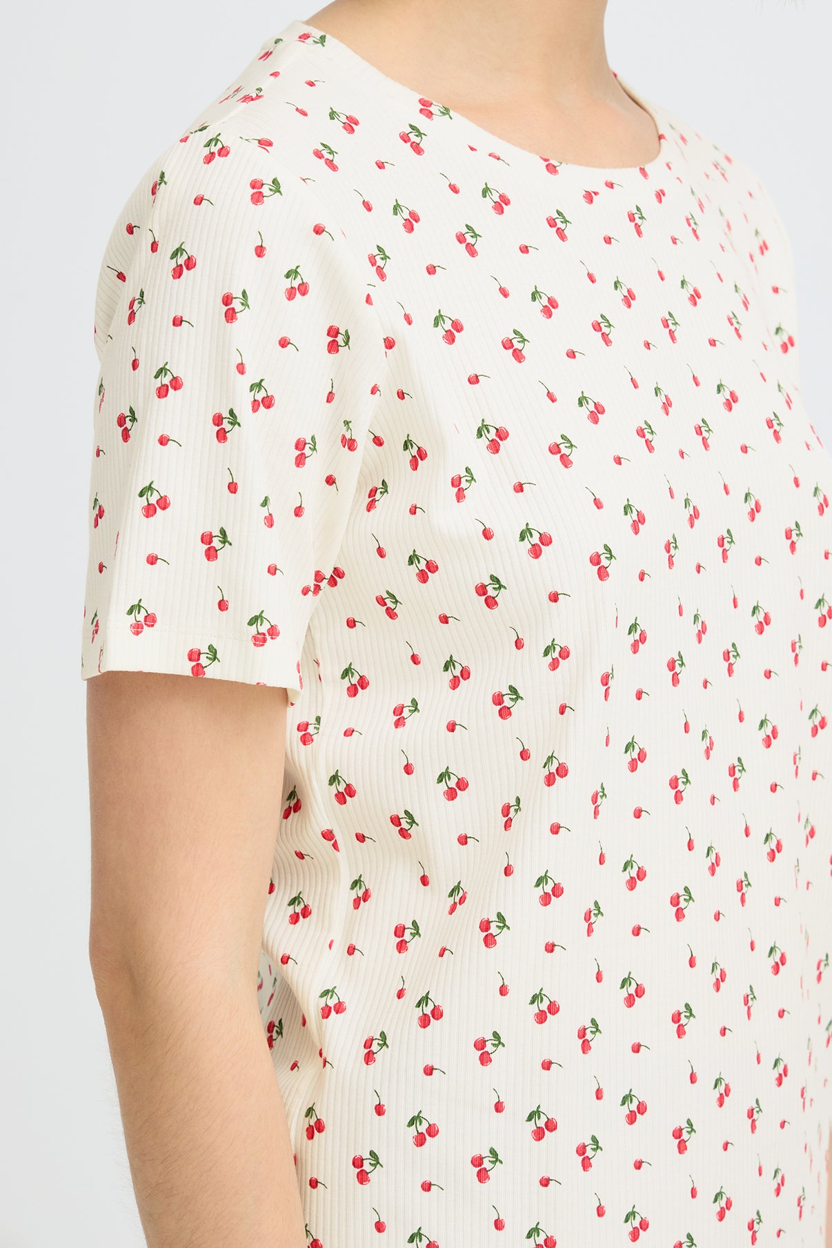 Kortærmet hvid t-shirt med små røde kirsebærprint og rund hals.