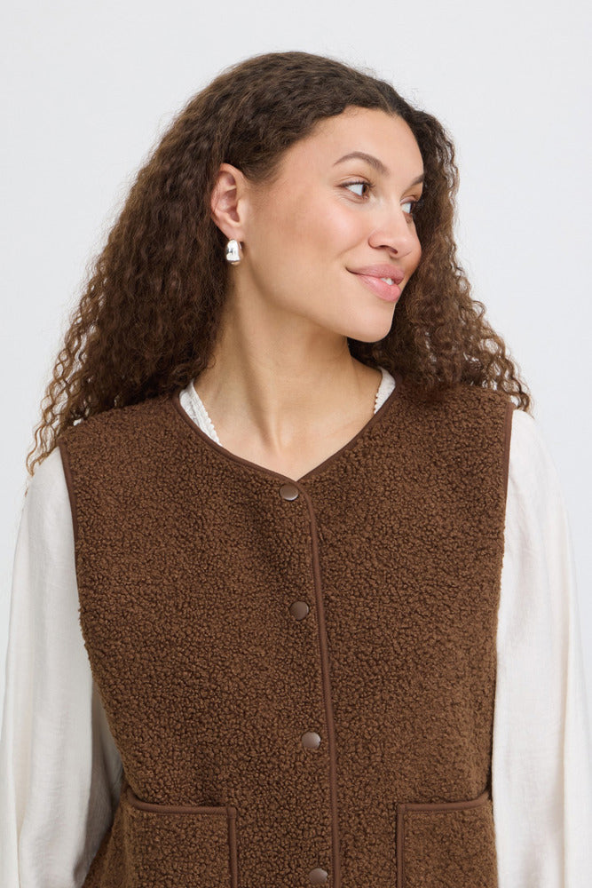 Brun teddyvest med knapper og lommer, uden ærmer, afslappet pasform.