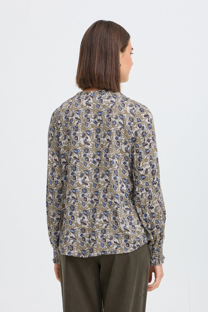 Langærmet bluse med lille, tætpakket mønster i grønne, beige og blå nuancer.