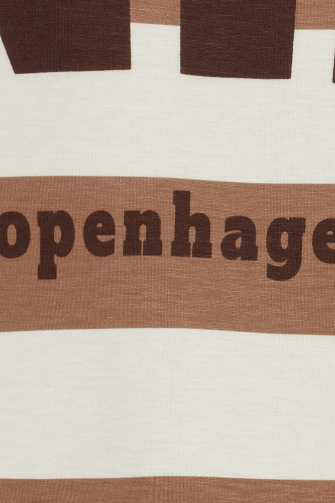 Detalje af stribet sweatshirt med brun tekst "Copenhagen" på beige og camello farvet stof.